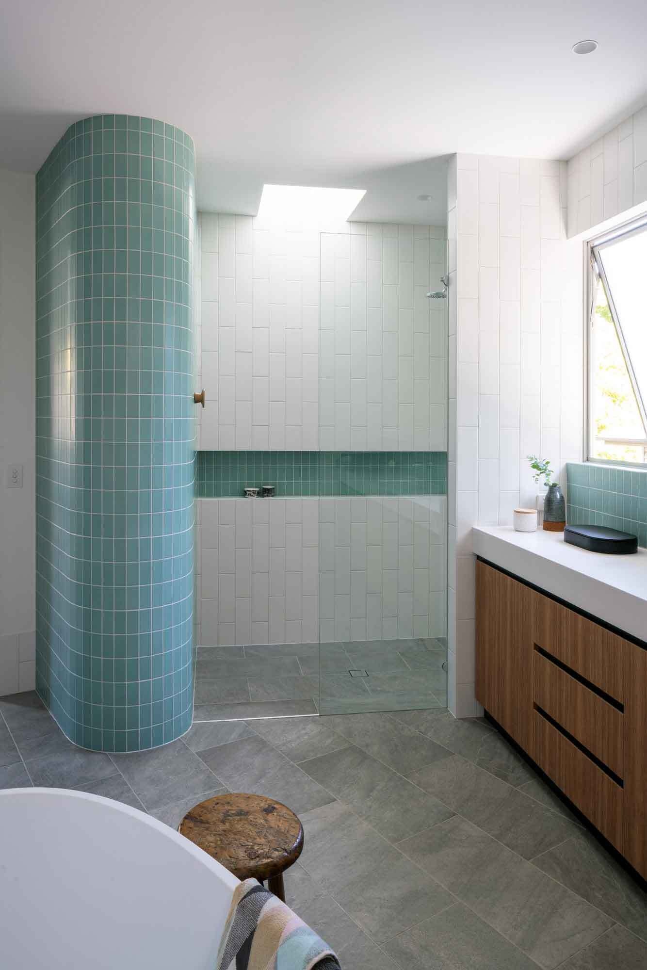 Skylights, curved walls, and turquoise tiles bring light and character into the home’s bathrooms.