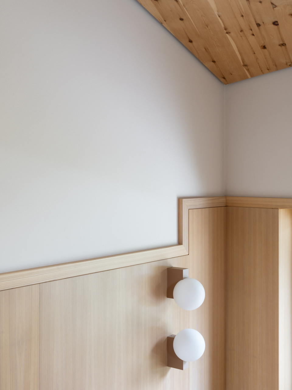 Skylit bedrooms use wood, and simple details to create calm private spaces above the valley.