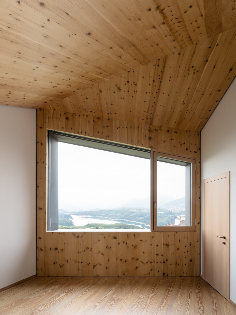 Skylit bedrooms use wood, and simple details to create calm private spaces above the valley.