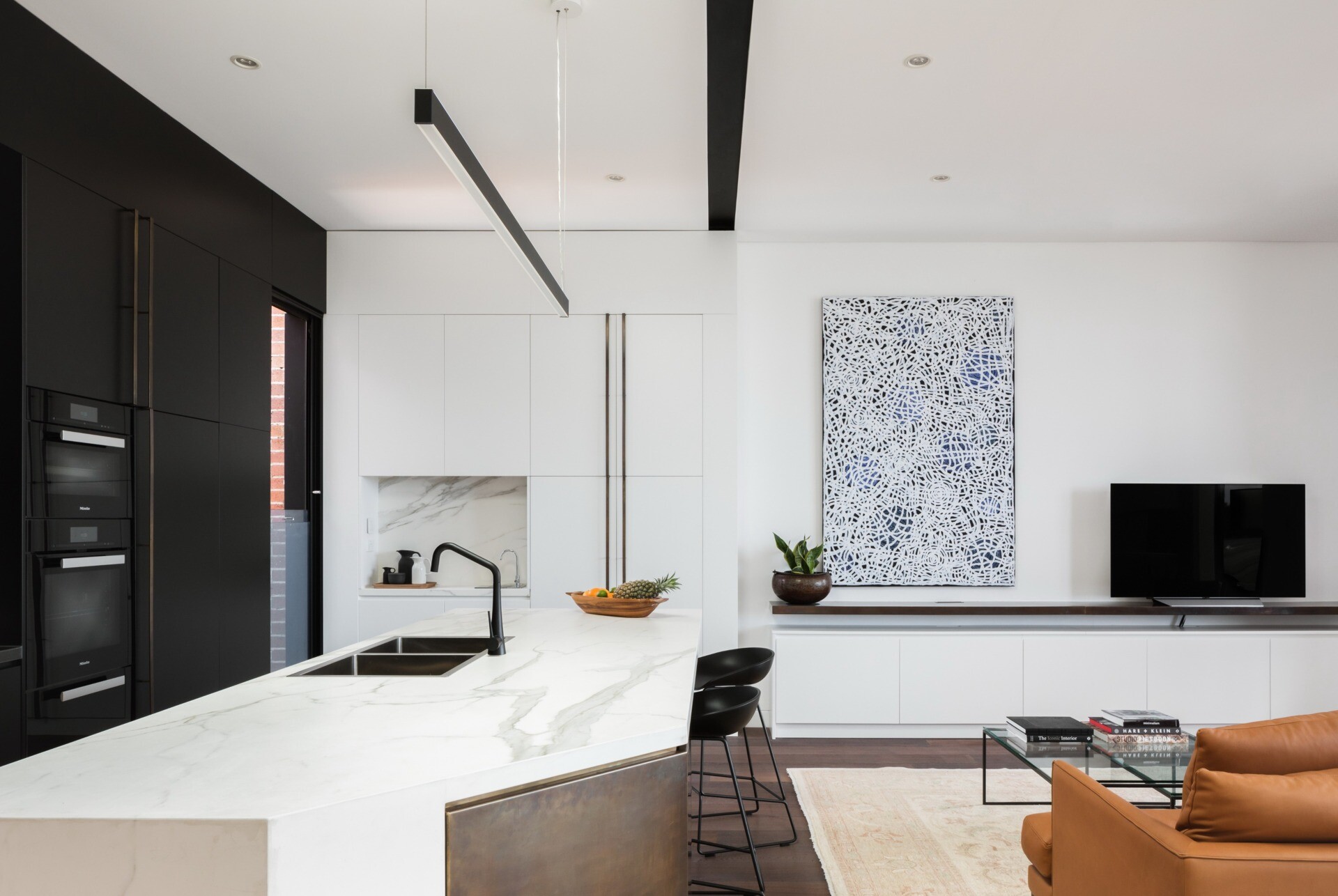 Black cabinetry paired with a white island keeps this kitchen bold yet bright.