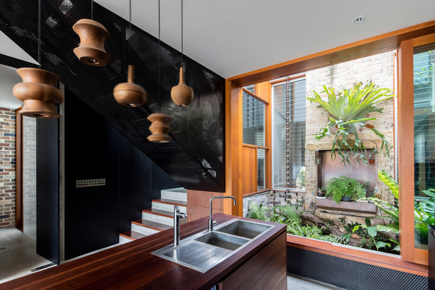 A fresh extension meets an original Sydney cottage with a plant filled courtyard that creates a soft, natural transition.