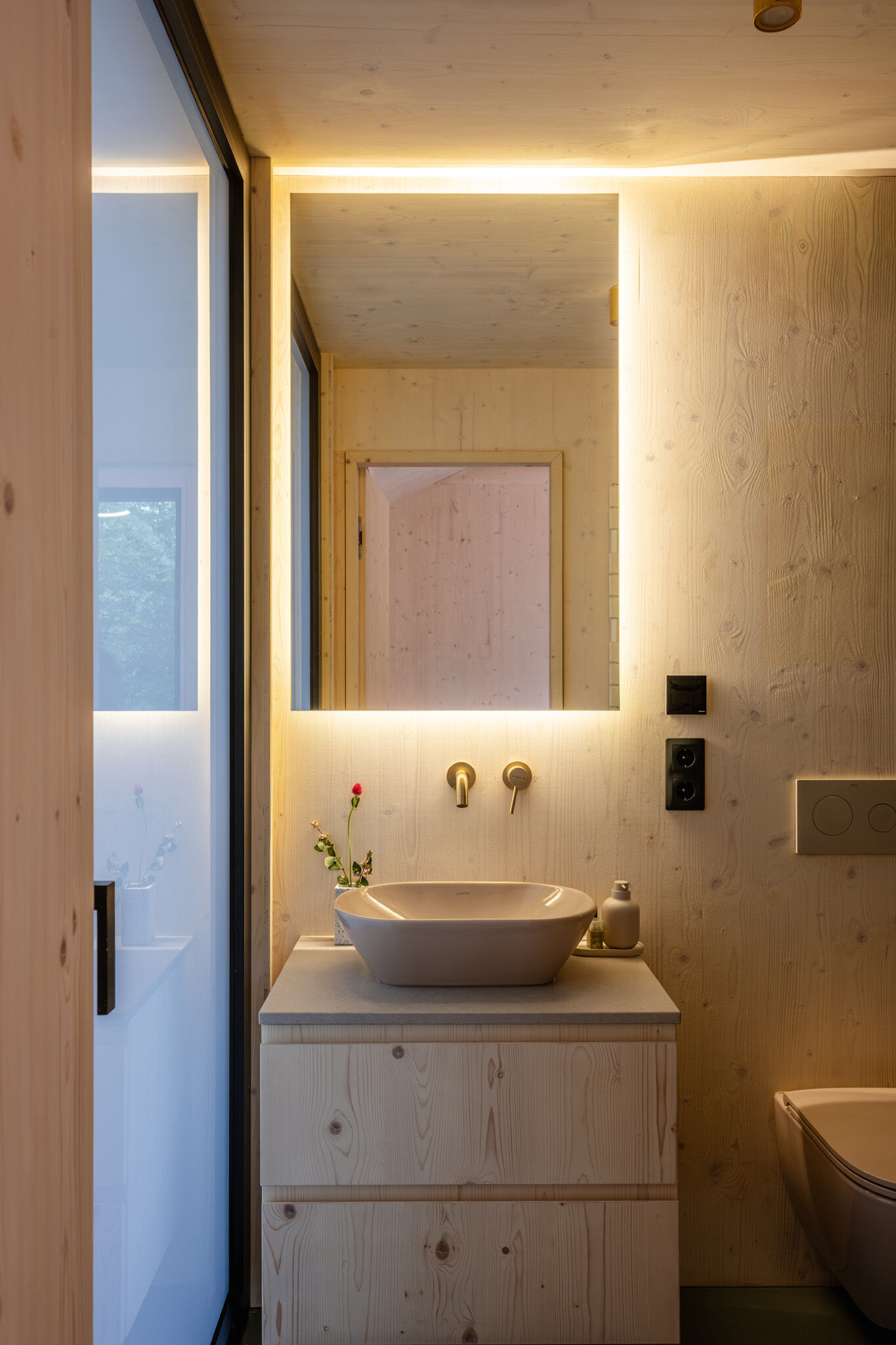 Minimal bathrooms with wood finishes.