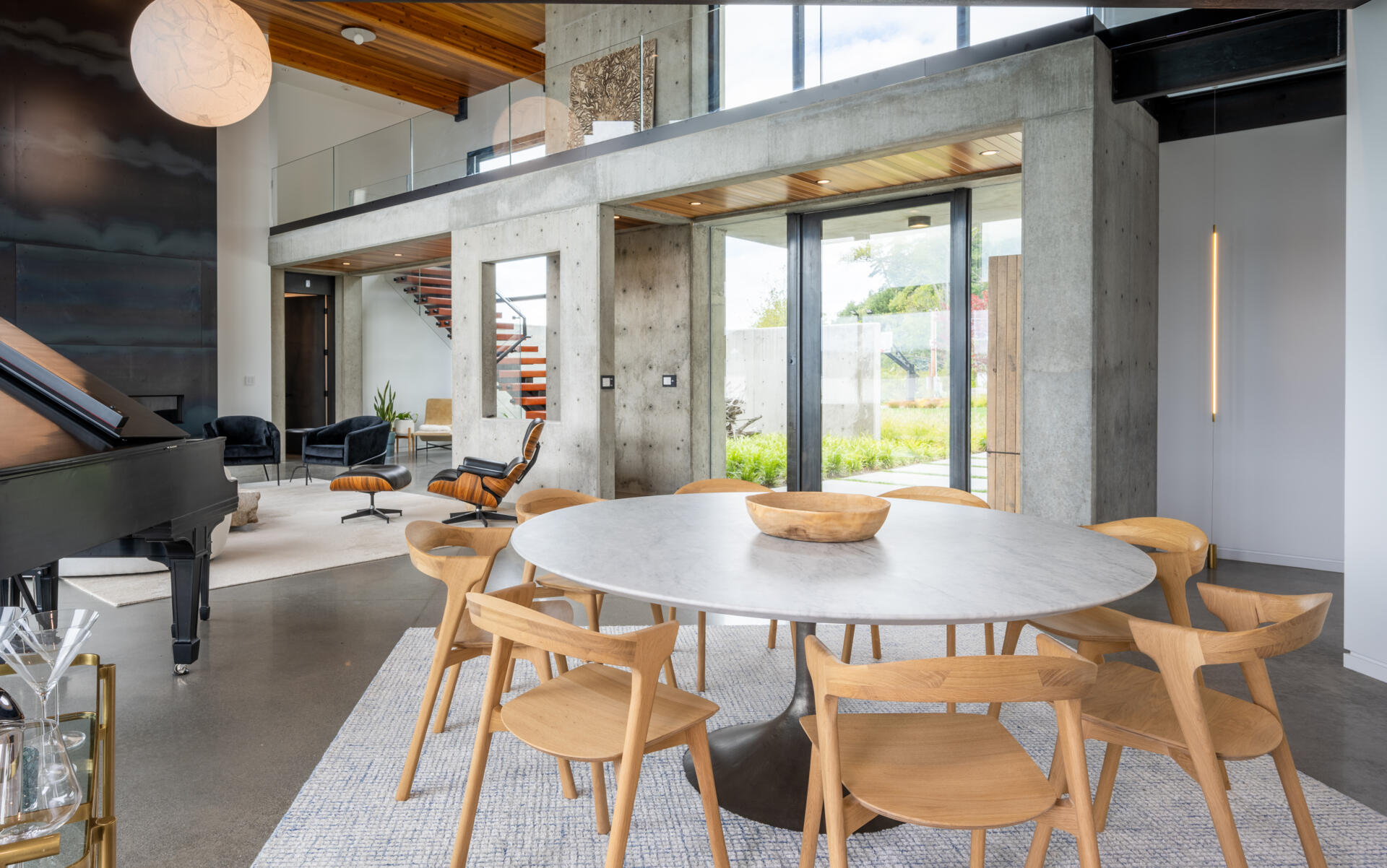 The dining area, with its round table, is integrated into the open great room between the living room and the kitchen.