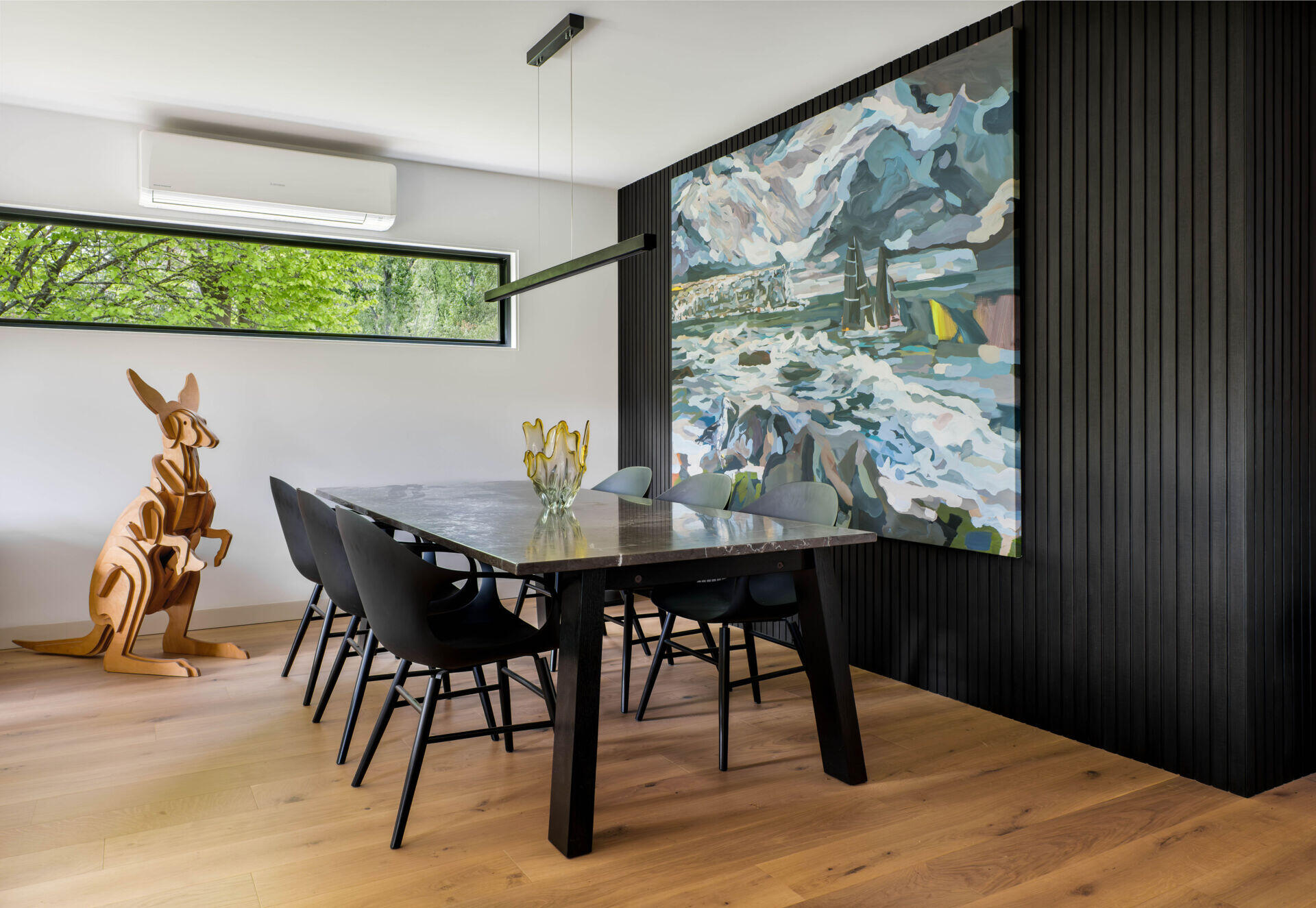 A calm dining space with new windows, warm textures and peaceful views of the mountains beyond.