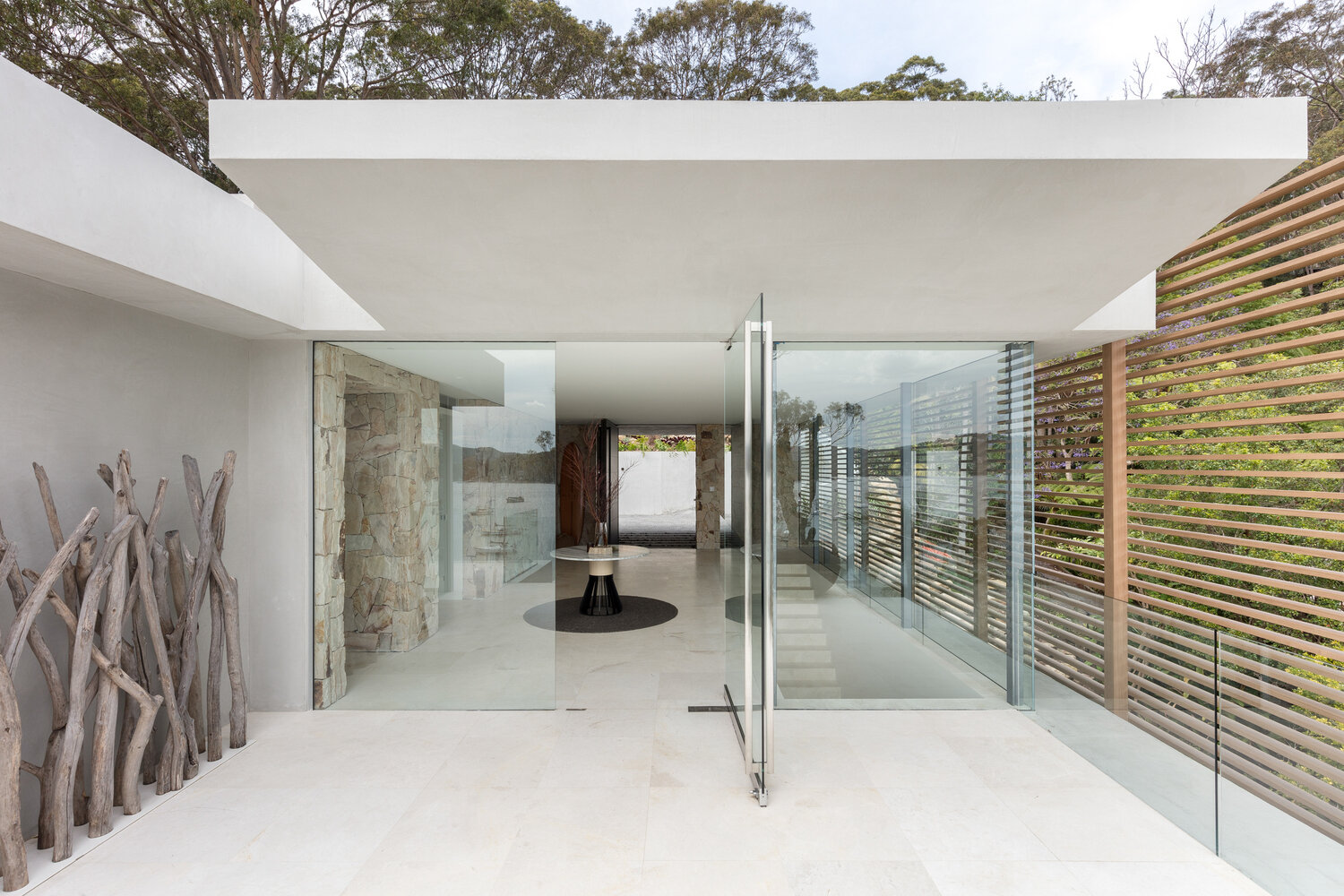 Floor to ceiling windows and invisible glass railings provide uninterrupted water views, bringing the outdoors into every room.