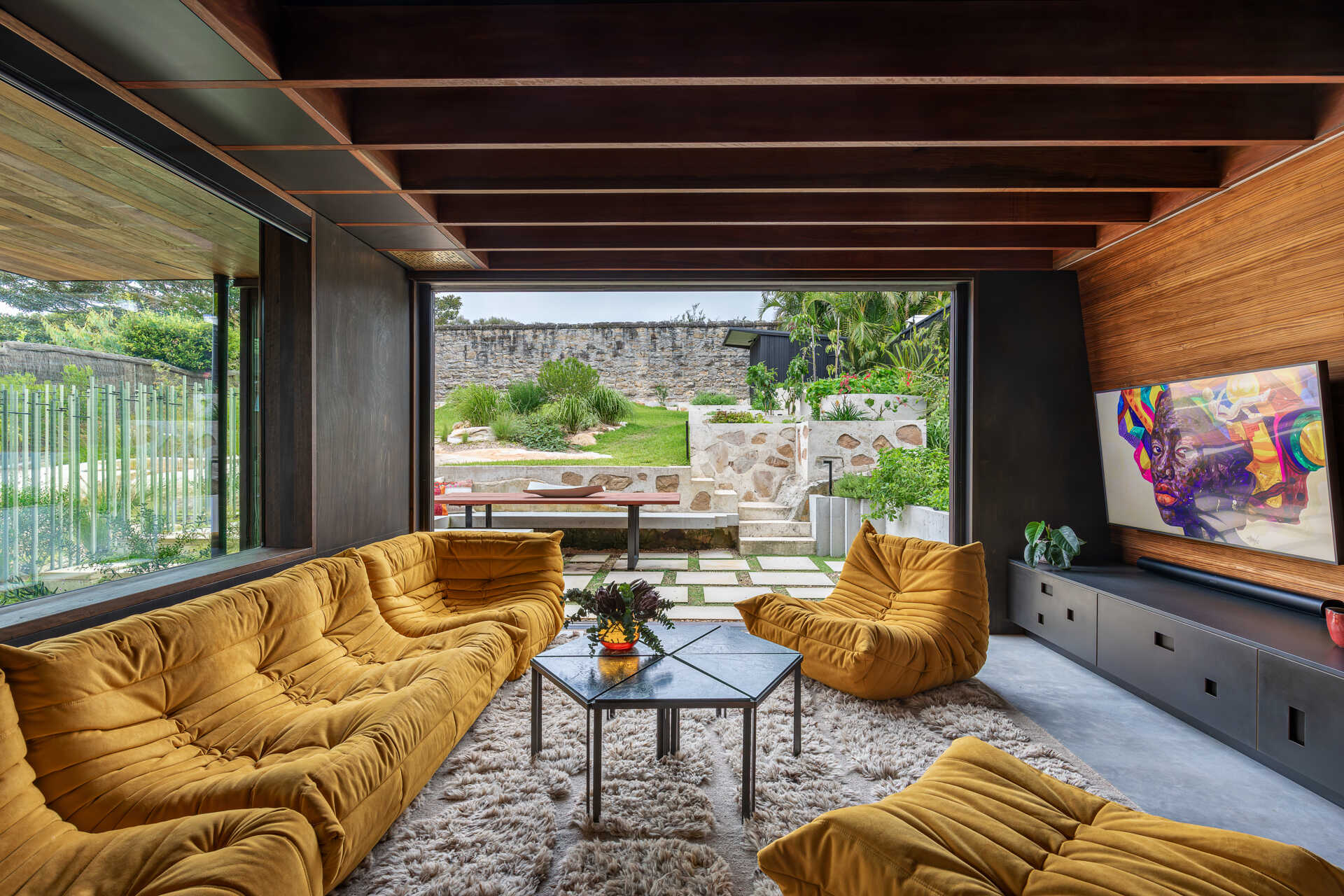 A casual living room with direct access to the garden and outdoor dining area.