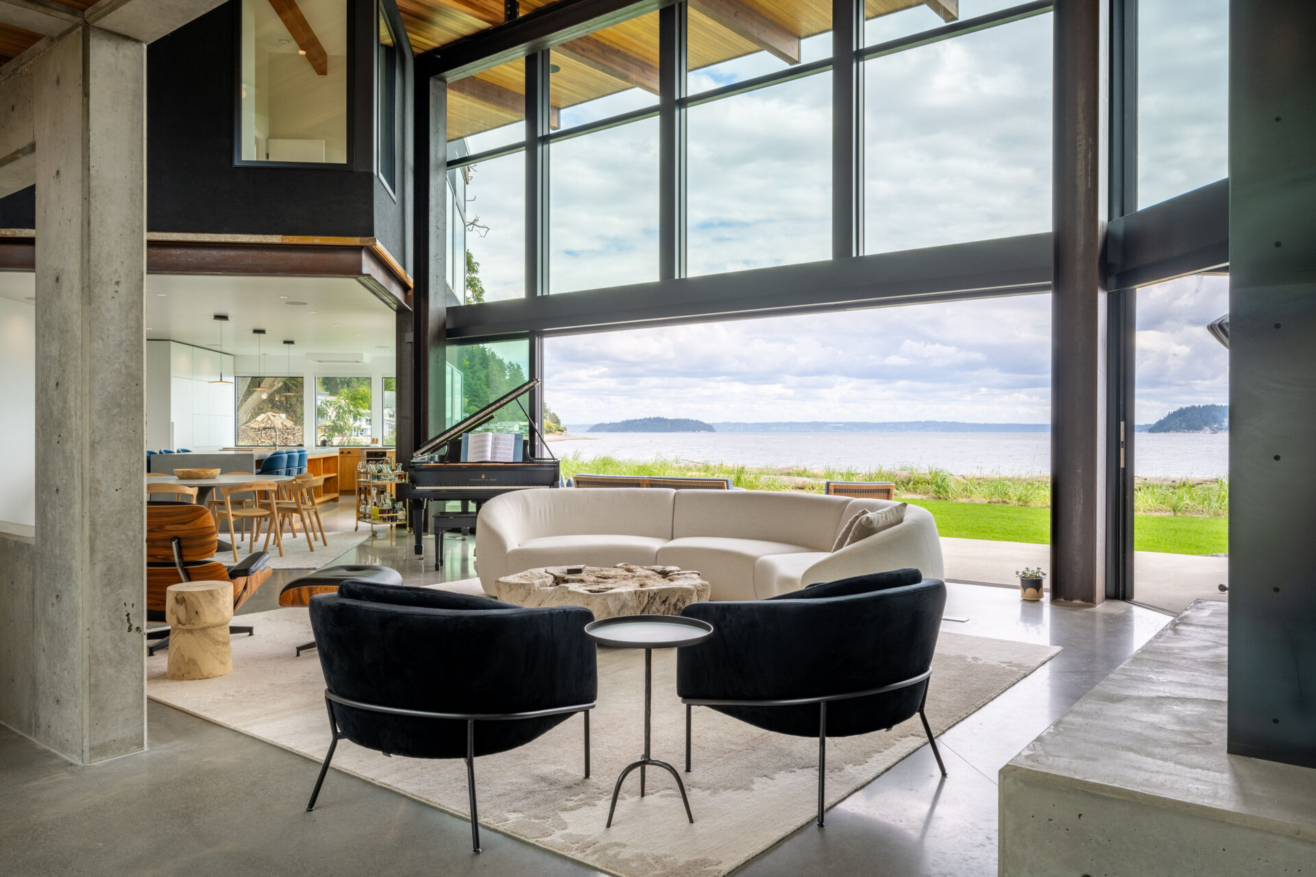 The great room acts as the heart of the house, linking two wings while opening fully to the water. Large sliding glass walls allow daily life to flow outdoors.