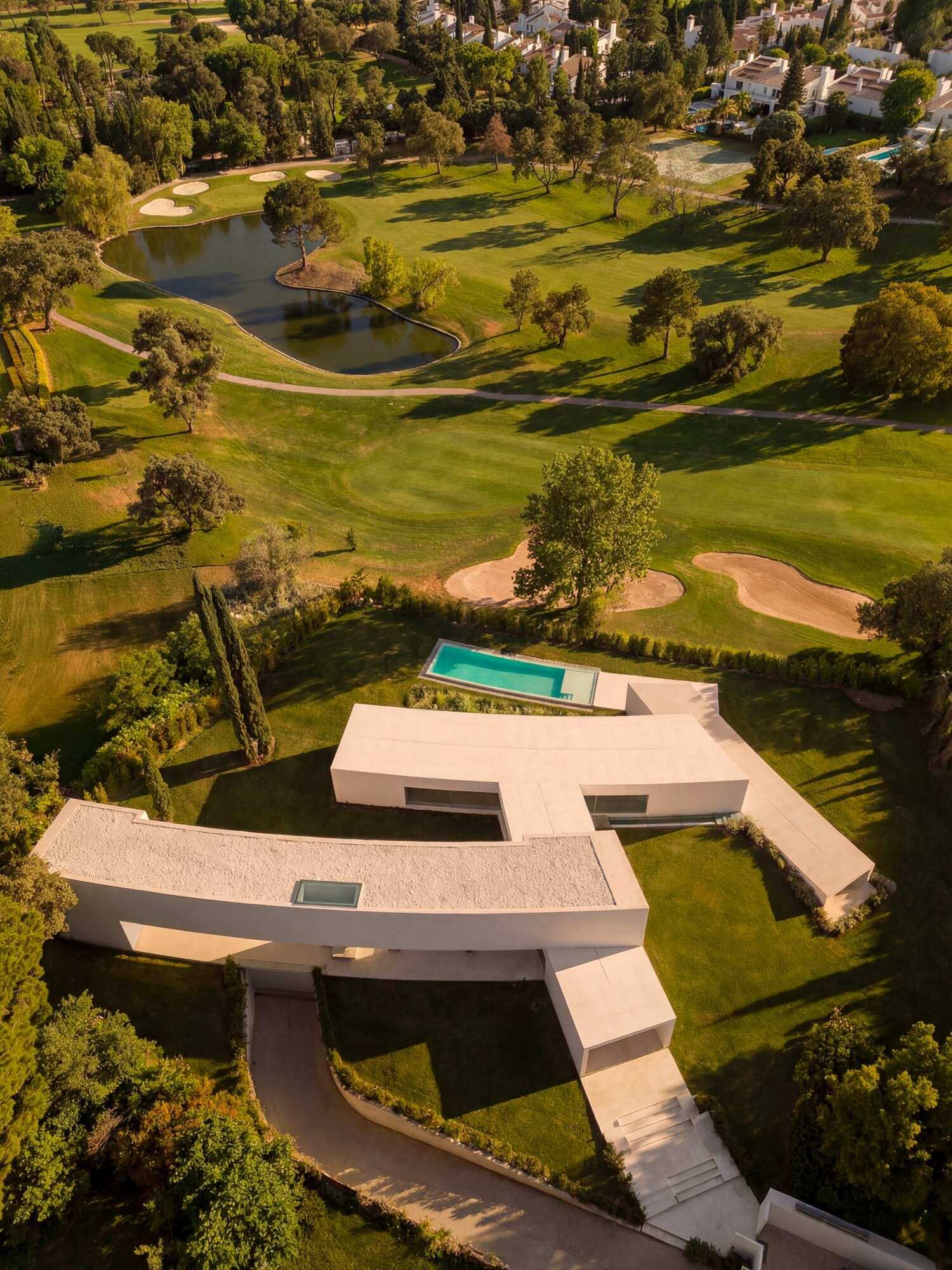 Architecture made from long curved volumes arranged in sequence, shaping circulation and movement throughout this Madrid house by Fran Silvestre Arquitectos.