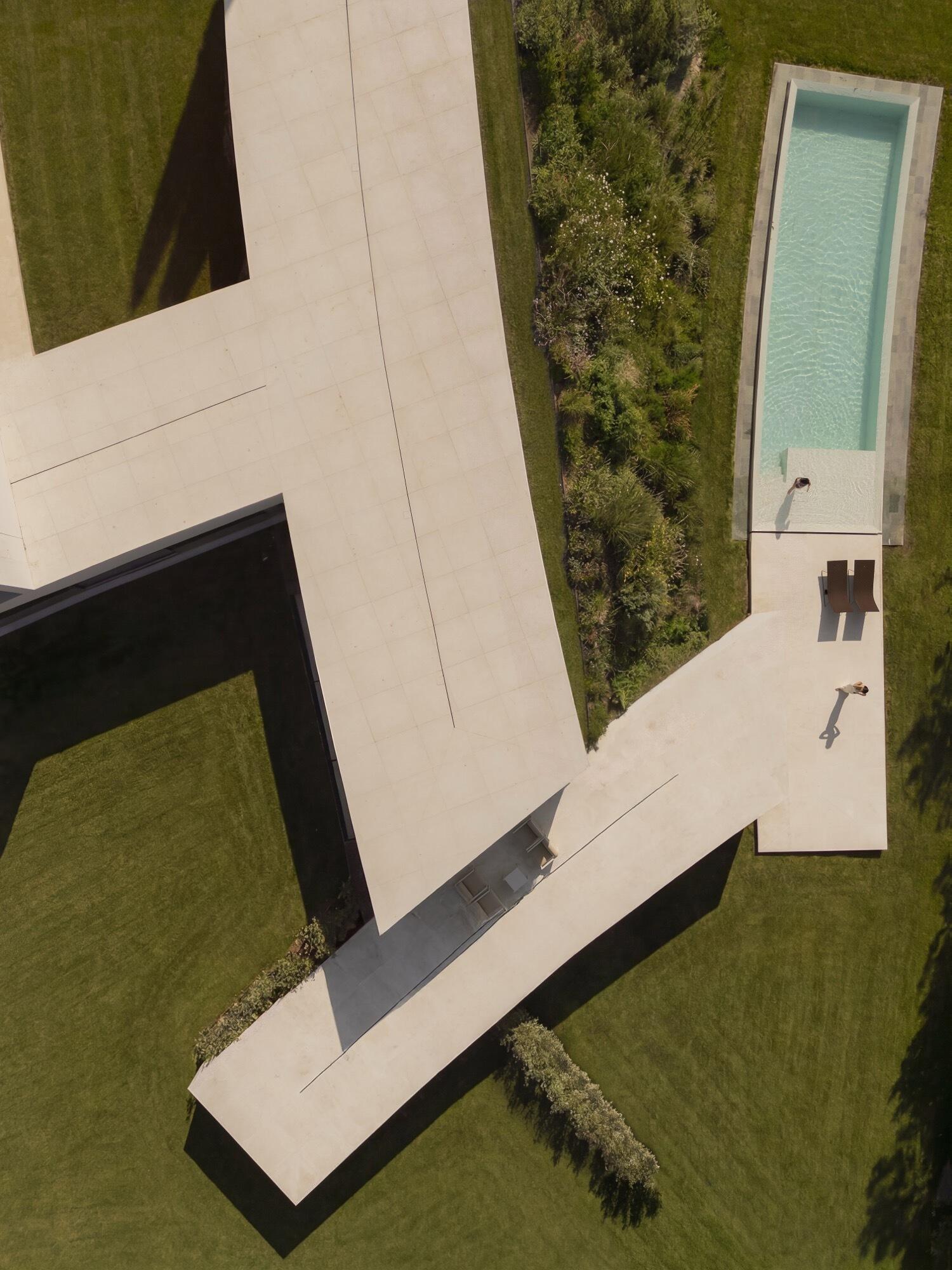 Architecture made from long curved volumes arranged in sequence, shaping circulation and movement throughout this Madrid house by Fran Silvestre Arquitectos.