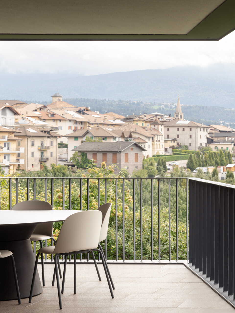 The dining space opens to a loggia overlooking the valley, blending interior comfort with expansive orchard views.