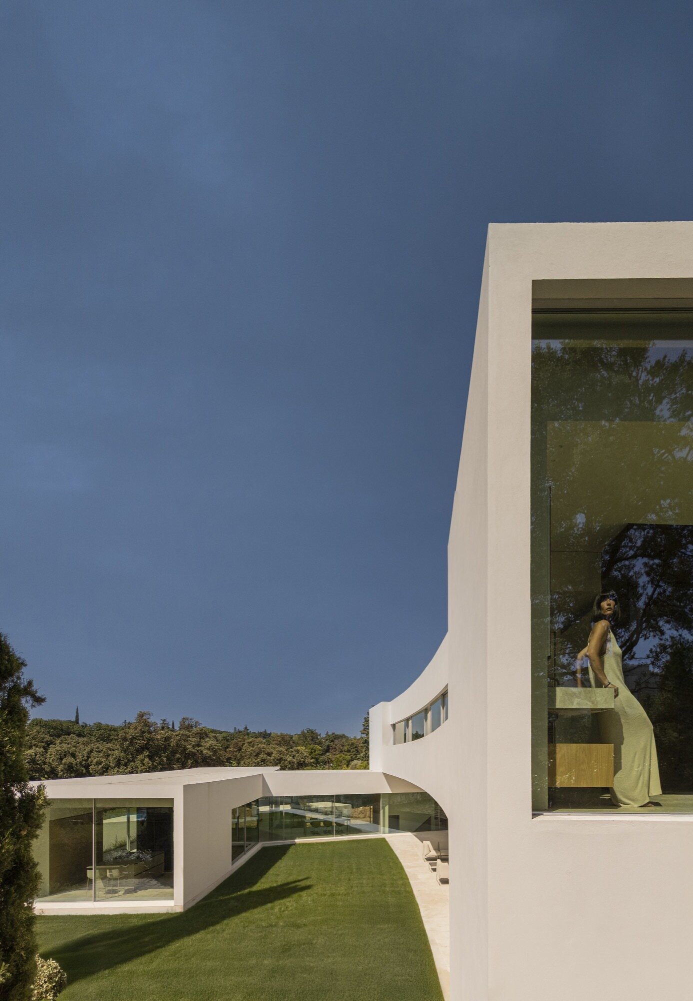 Architecture made from long curved volumes arranged in sequence, shaping circulation and movement throughout this Madrid house by Fran Silvestre Arquitectos.