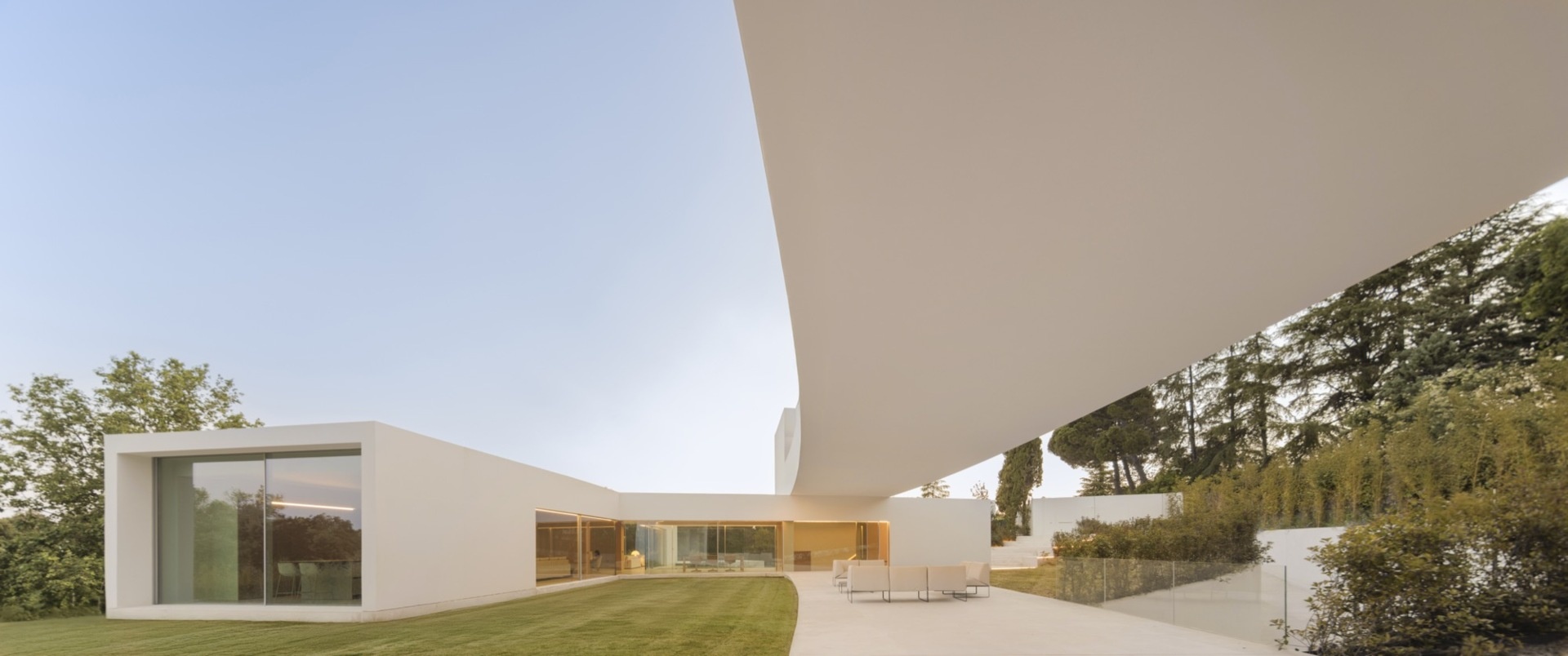 Architecture made from long curved volumes arranged in sequence, shaping circulation and movement throughout this Madrid house by Fran Silvestre Arquitectos.