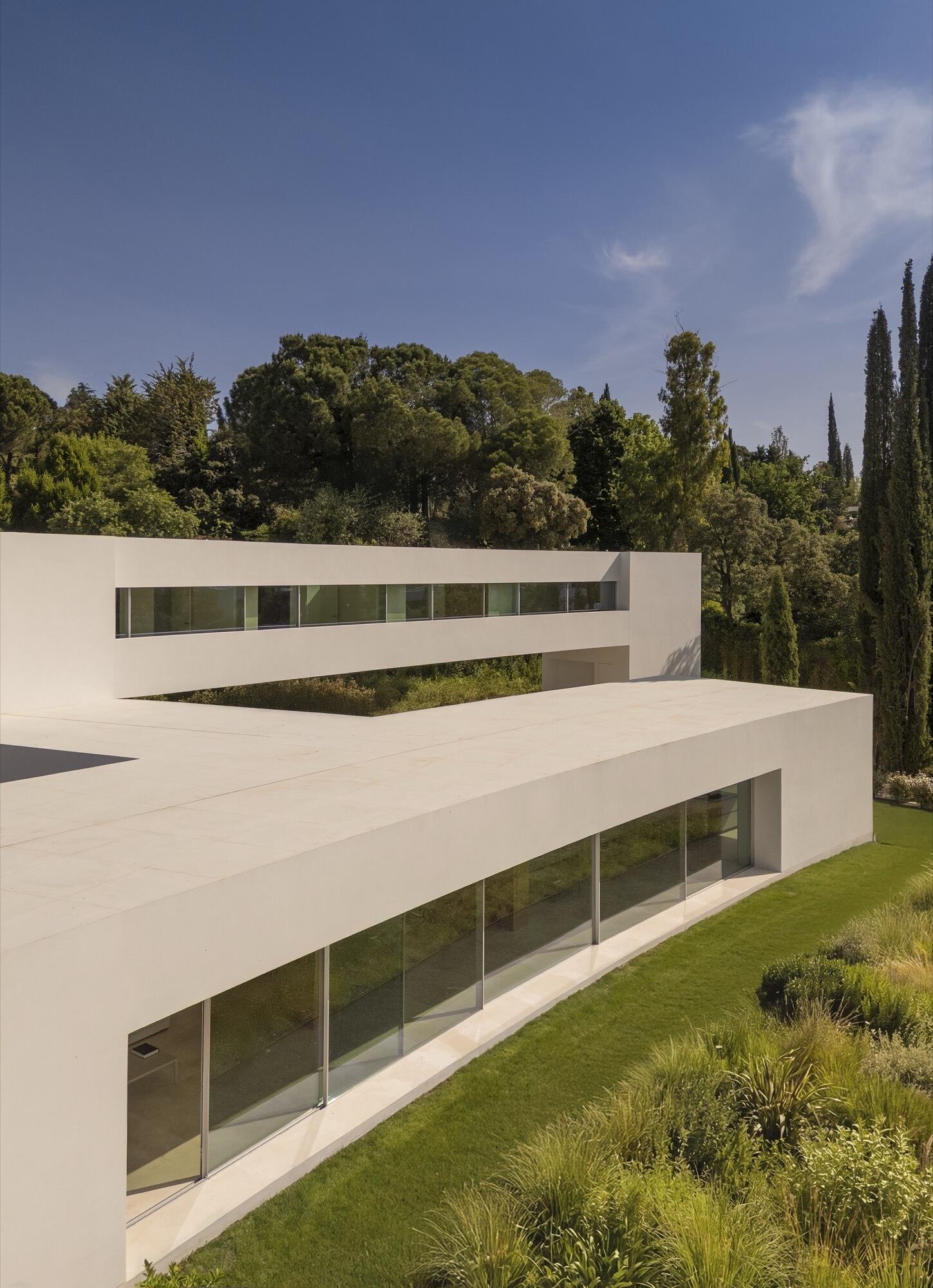 Architecture made from long curved volumes arranged in sequence, shaping circulation and movement throughout this Madrid house by Fran Silvestre Arquitectos.