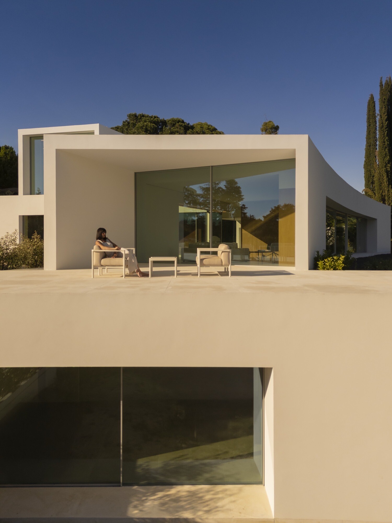 Architecture made from long curved volumes arranged in sequence, shaping circulation and movement throughout this Madrid house by Fran Silvestre Arquitectos.