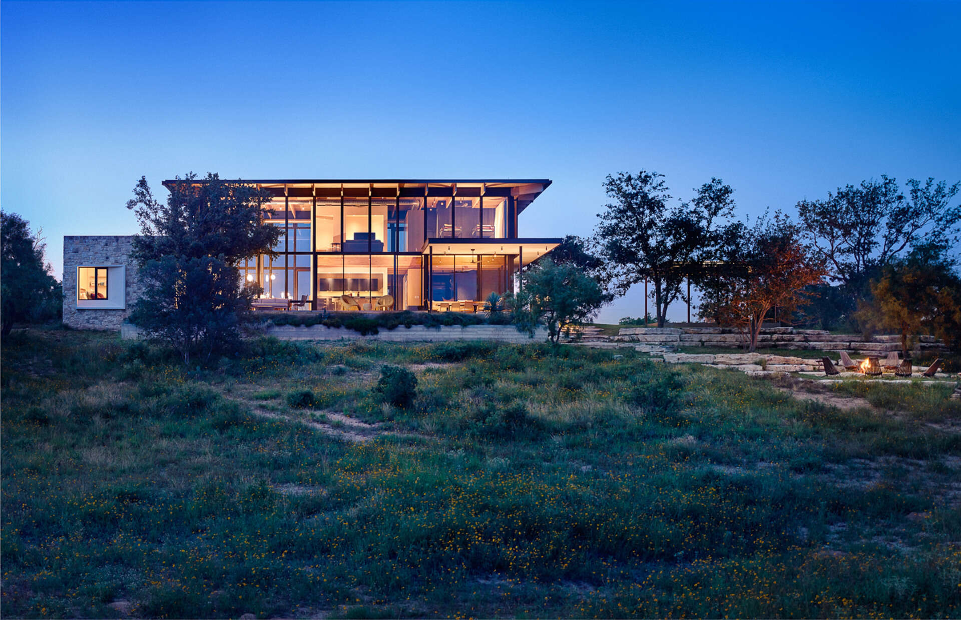 Locally sourced limestone, Douglas fir and shou sugi ban create a rustic yet refined exterior that blends this home into the Texas landscape.