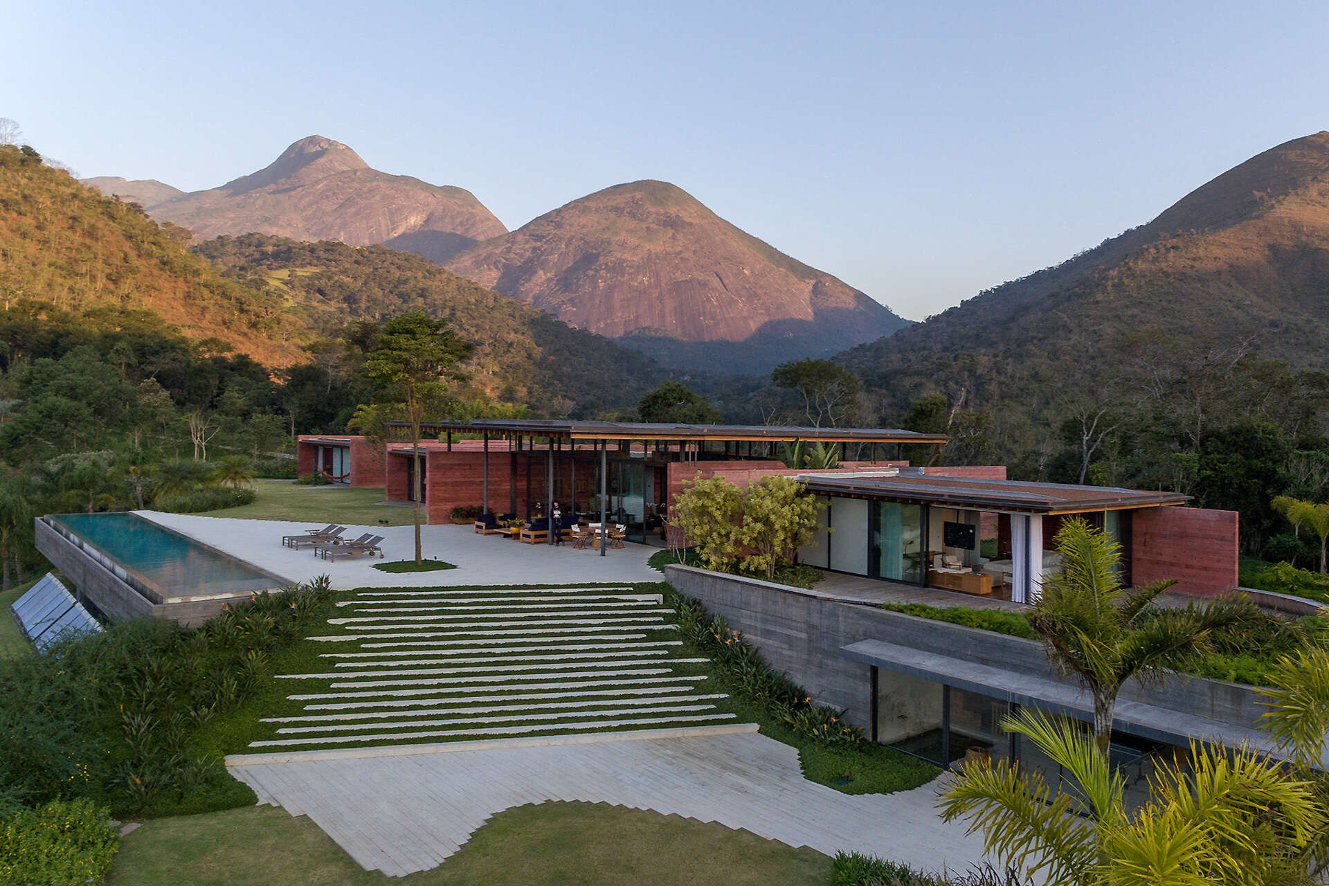 Casa Terra sits on a sloped mountain site in Itaipava, with patios and an infinity pool designed to fully embrace the surrounding views.