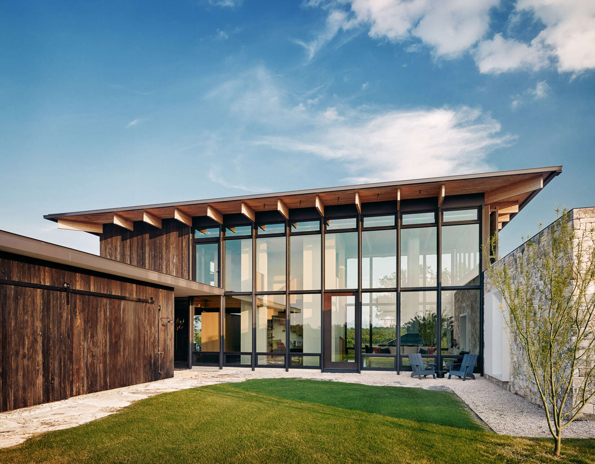 Locally sourced limestone, Douglas fir and shou sugi ban create a rustic yet refined exterior that blends this home into the Texas landscape.