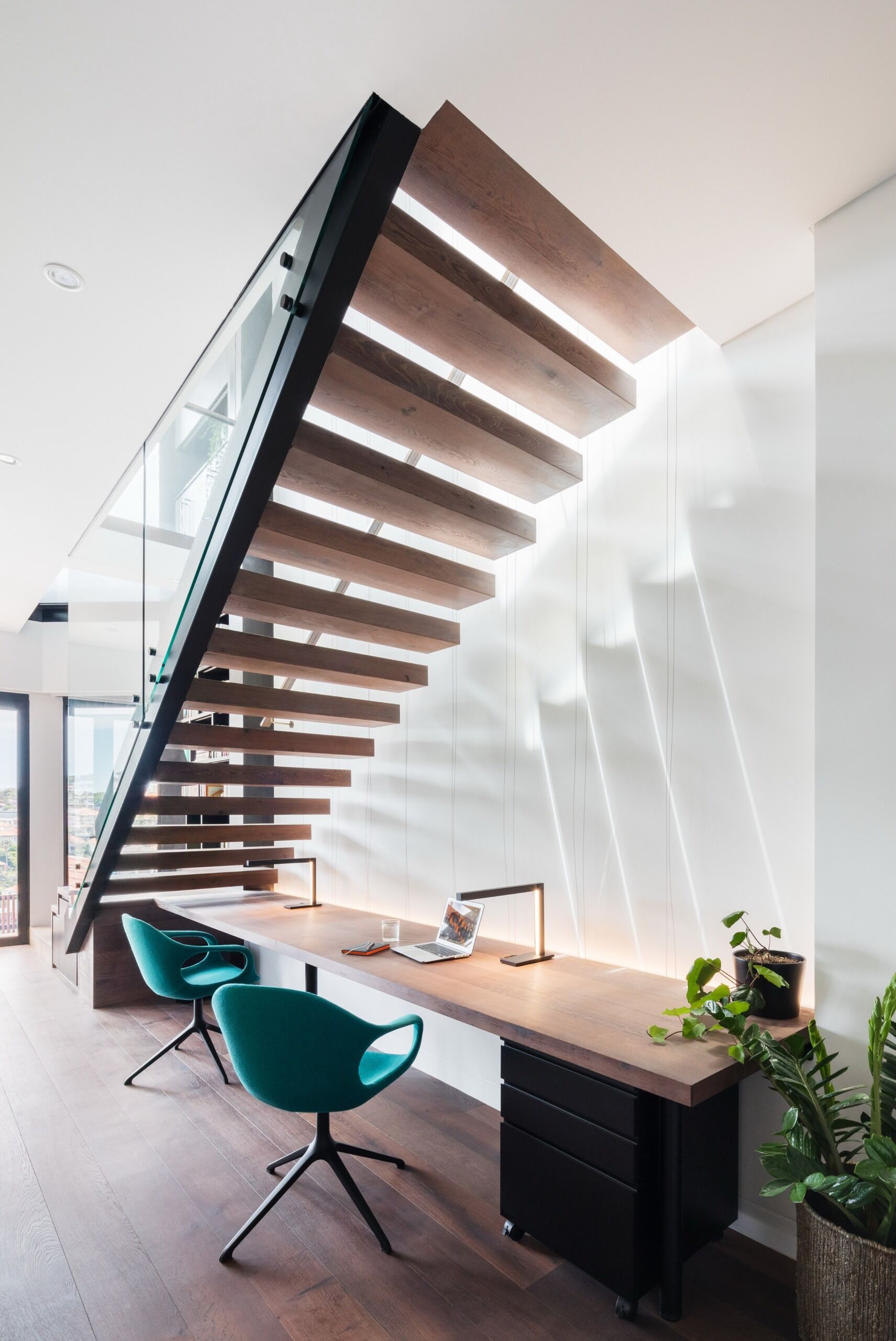 Cantilevered stairs double as a design feature, with a shared desk tucked neatly underneath.
