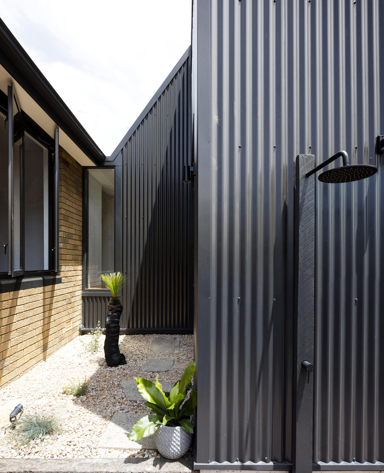 Outdoor living spaces and an external shower strengthen the home’s connection to garden and lifestyle.