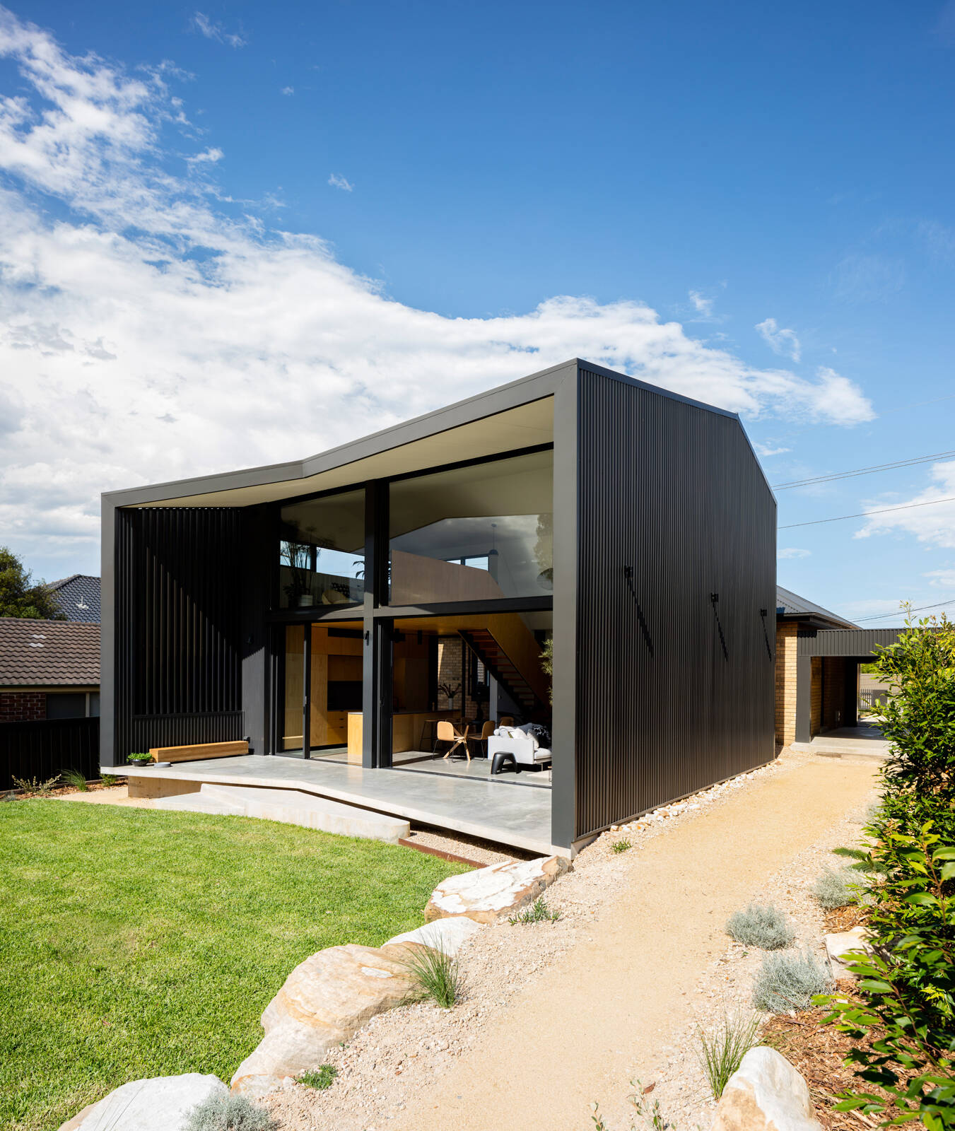 Outdoor living spaces and an external shower strengthen the home’s connection to garden and lifestyle.