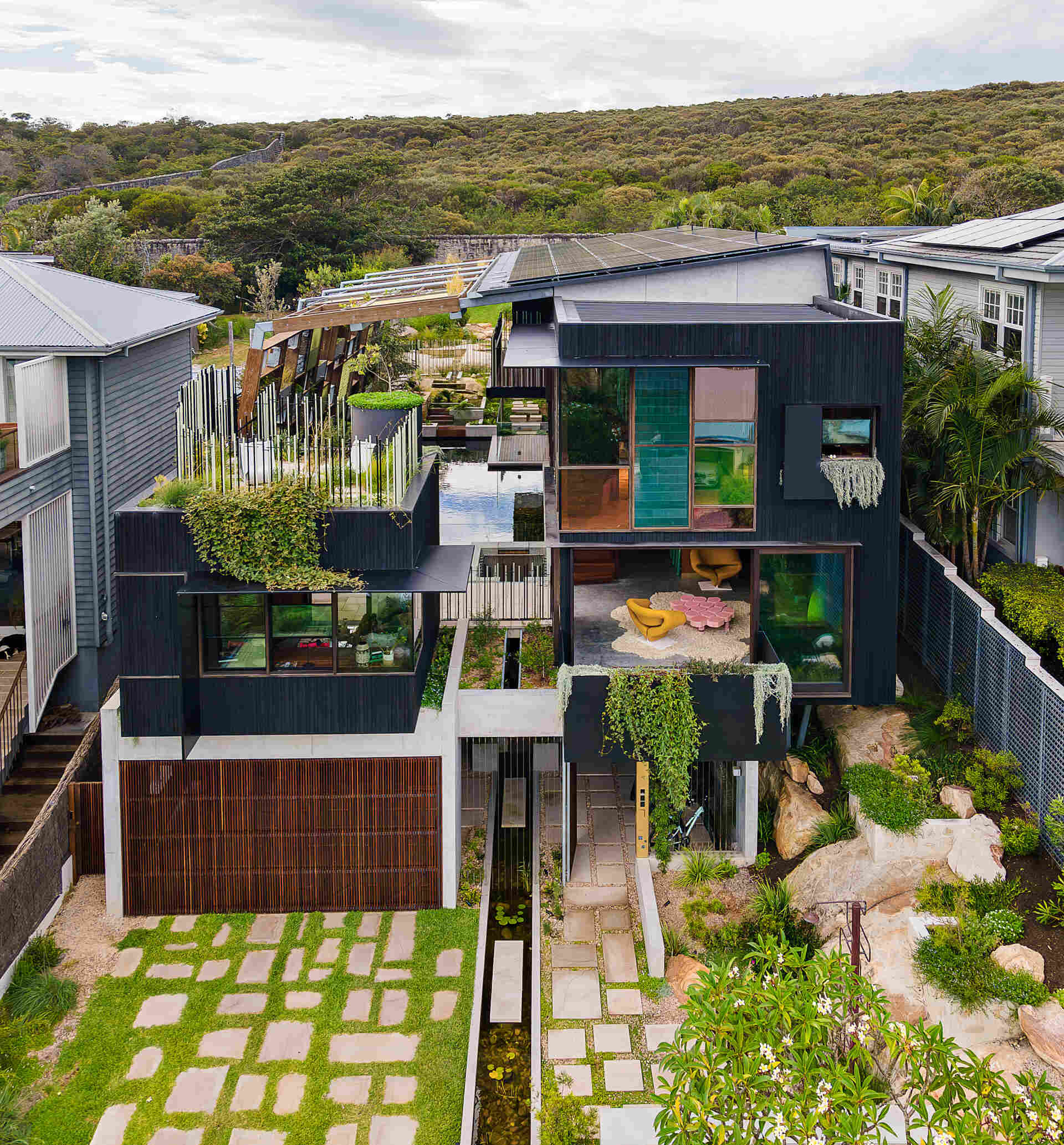Step inside a carbon positive Sydney home designed around water, light, and plant canopies. The exterior uses durable Shou Sugi Ban timber and a garage integrated seamlessly into the facade.