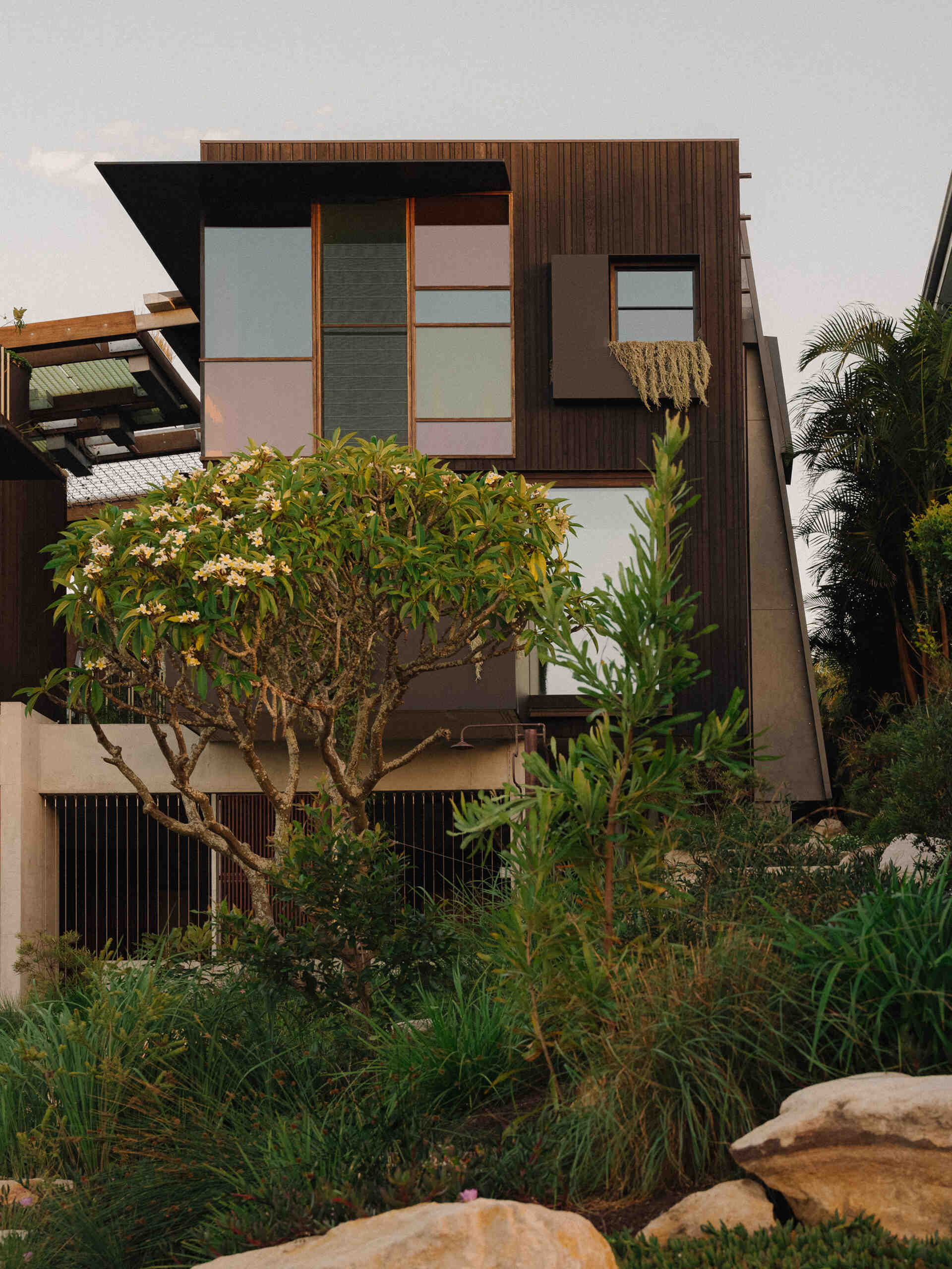 Step inside a carbon positive Sydney home designed around water, light, and plant canopies. The exterior uses durable Shou Sugi Ban timber and a garage integrated seamlessly into the facade.