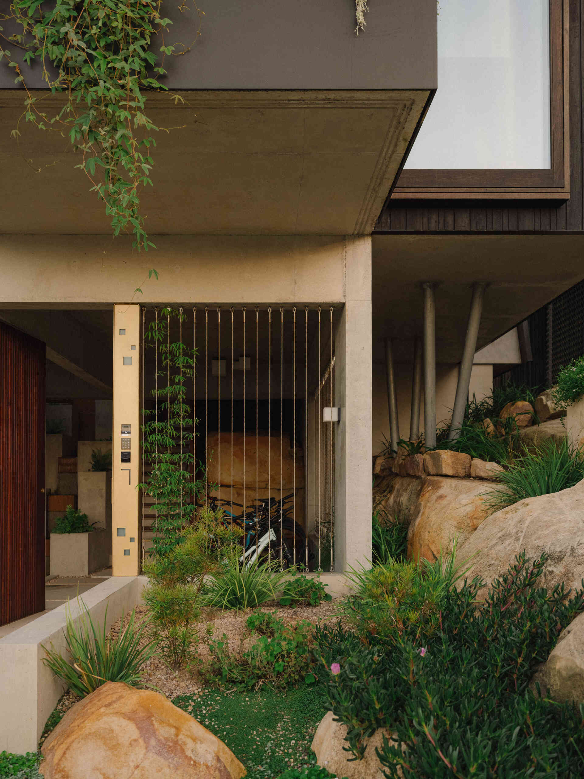 Cross a pond, step on stones, and ascend alongside a cascading waterfall to enter the living spaces.