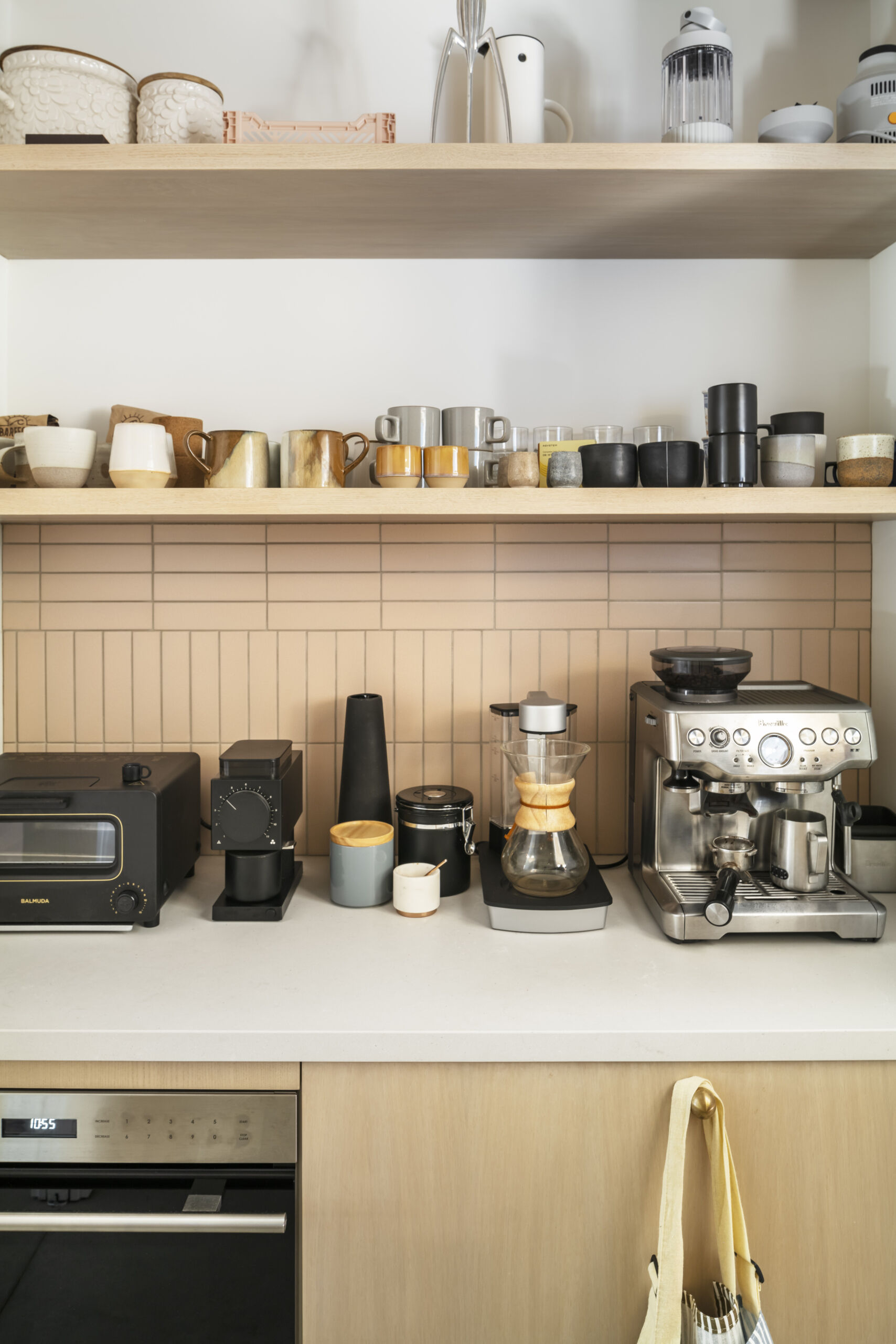 The dining and kitchen areas sit within the same public zone, designed for everyday use rather than separation. Polished concrete floors continue through these spaces, paired with white oak and ceramic tile for subtle variation.