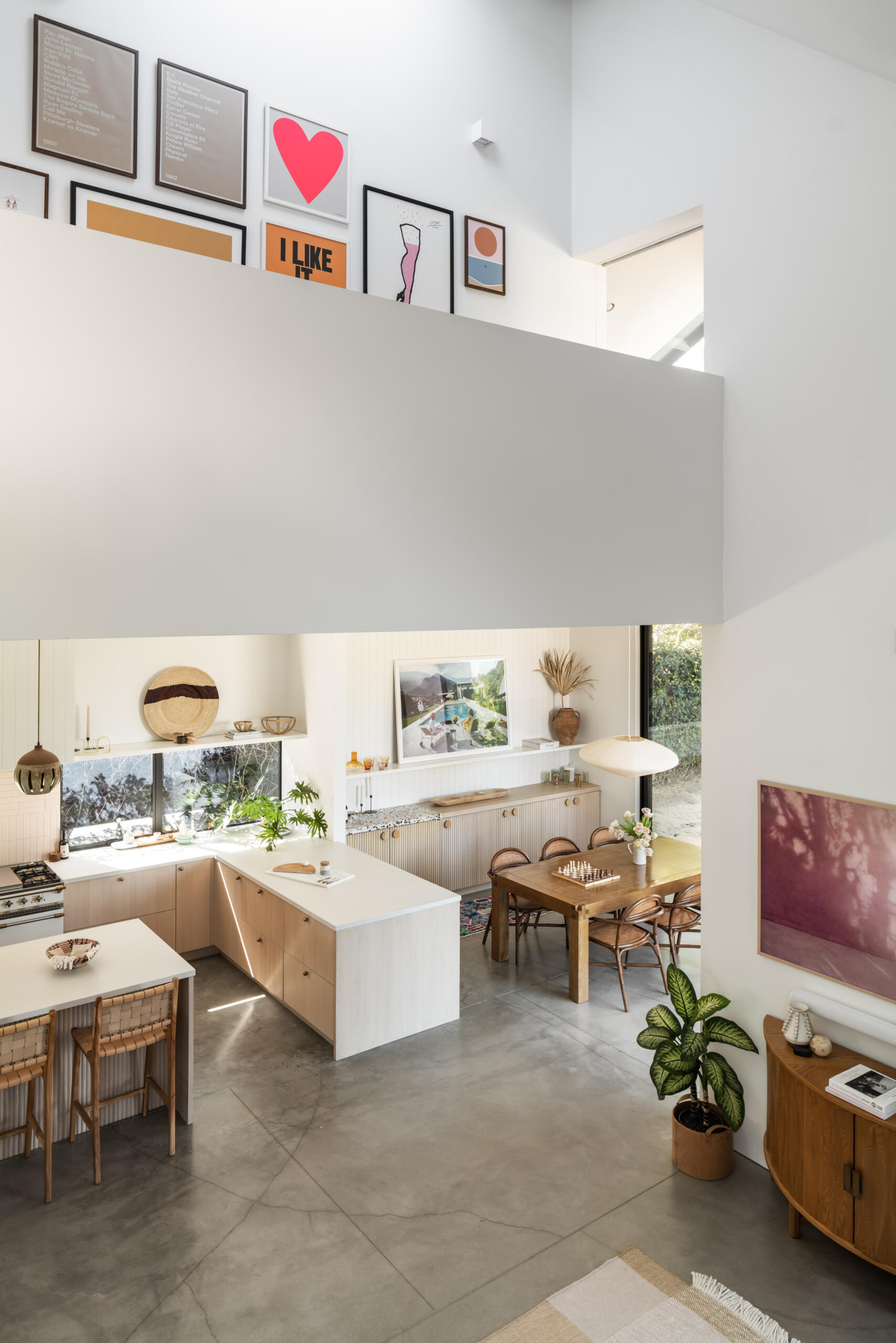 The dining and kitchen areas sit within the same public zone, designed for everyday use rather than separation. Polished concrete floors continue through these spaces, paired with white oak and ceramic tile for subtle variation.
