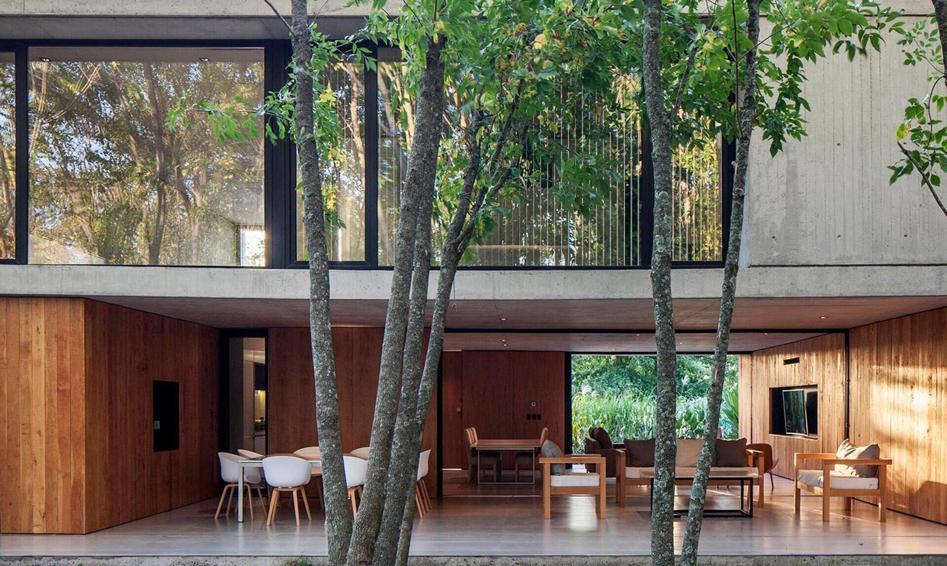 Sliding glass walls allow the living room to open completely to the outdoors, creating a seamless indoor outdoor environment.