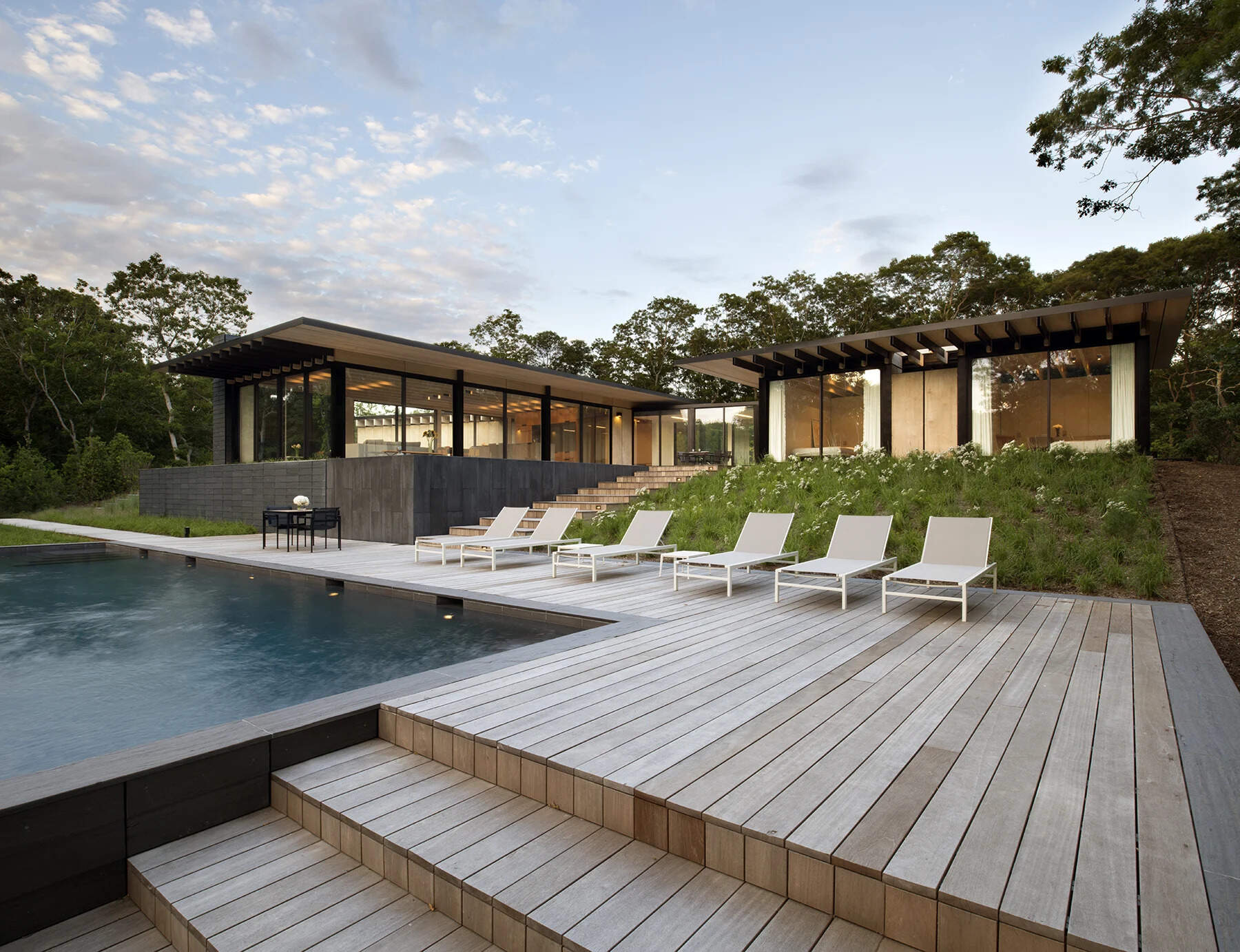 A swimming pool, deck, and reflecting pool create a layered backyard that leads naturally from outdoor living spaces back into the heart of the home.