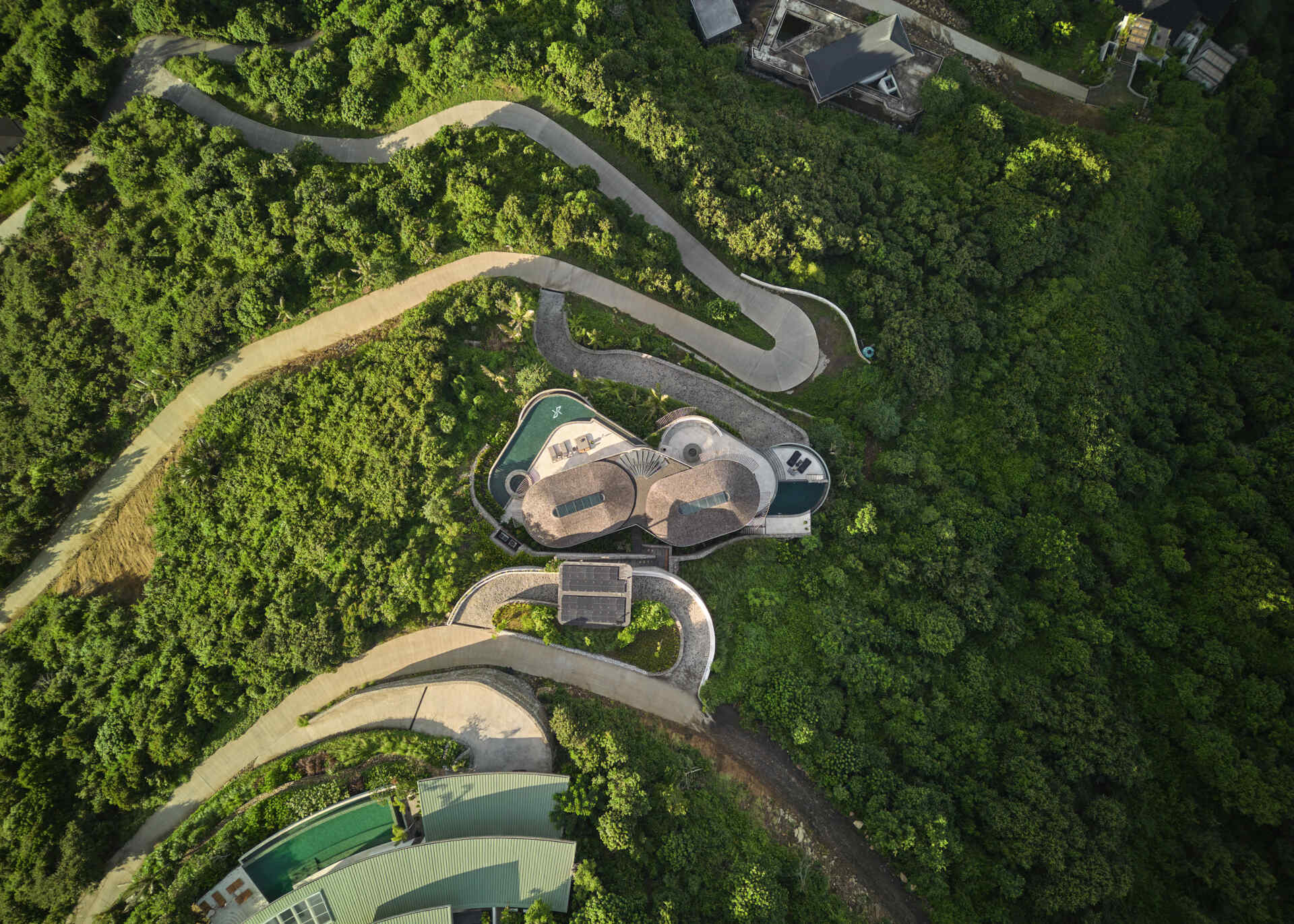 This hillside house steps down one of Tampah Hills’ steepest slopes, using circles and tangents to shape space and circulation.