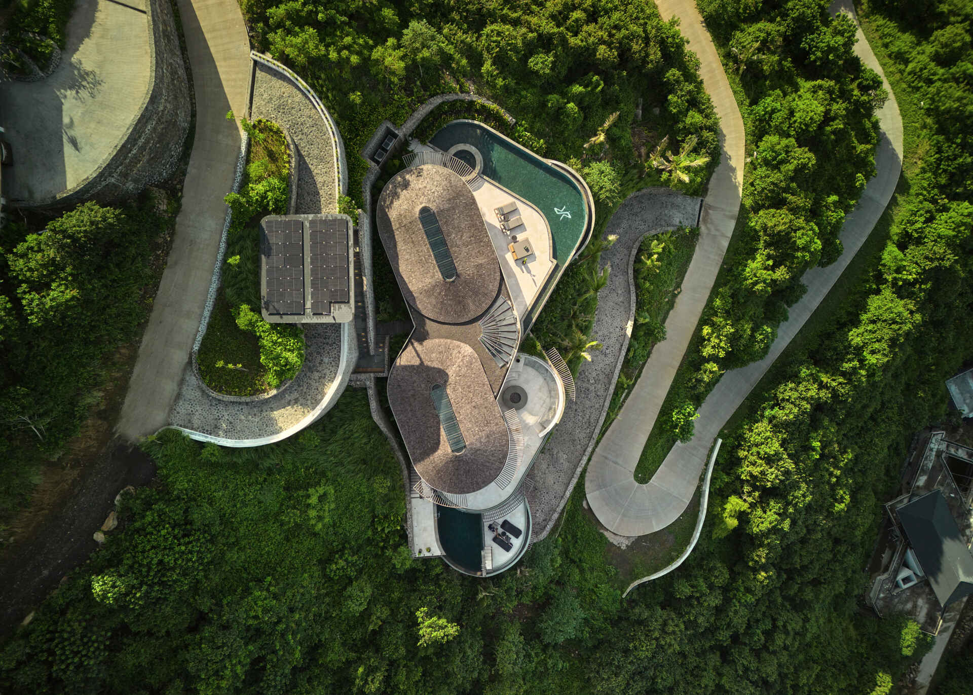This hillside house steps down one of Tampah Hills’ steepest slopes, using circles and tangents to shape space and circulation.