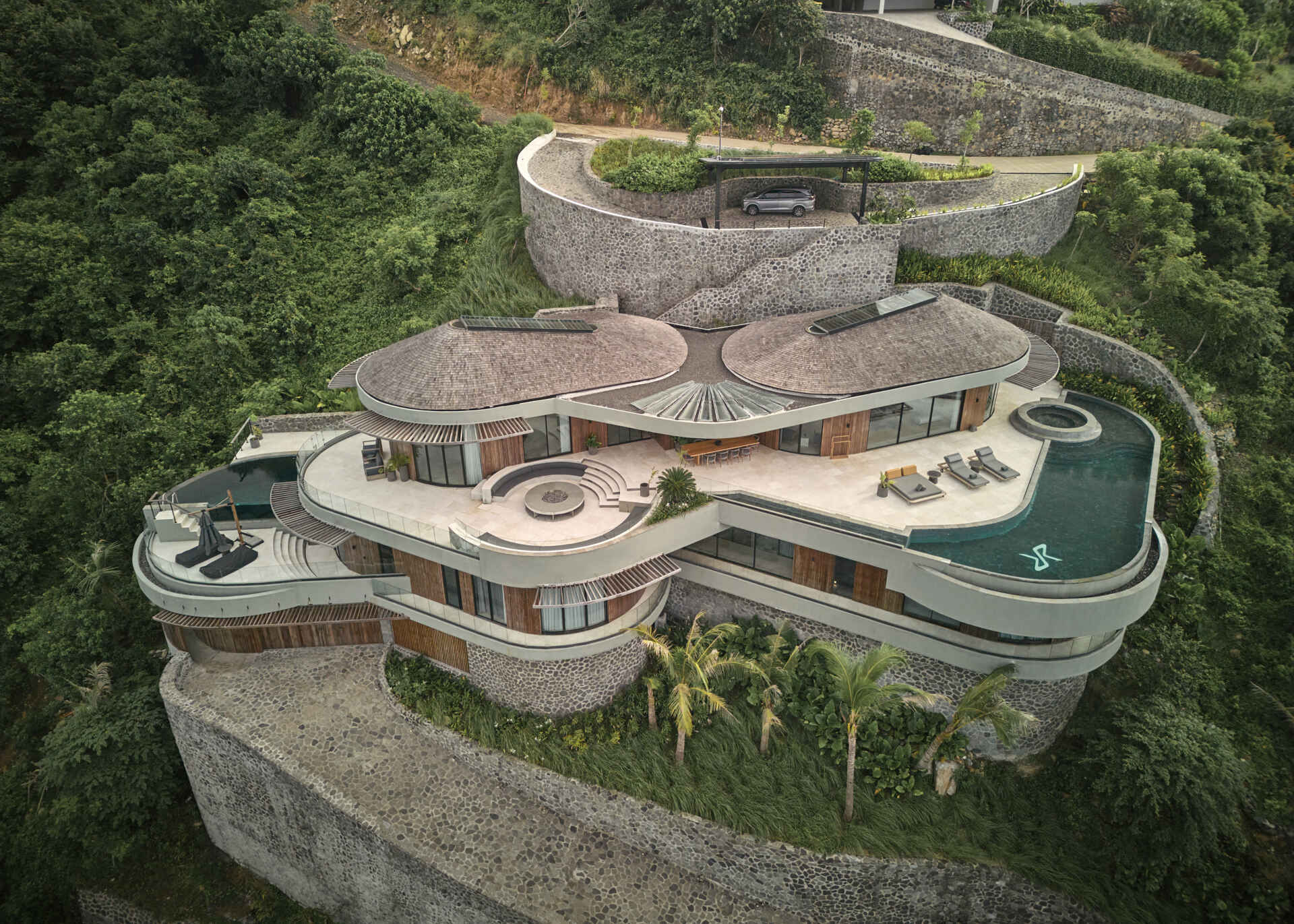 This hillside house steps down one of Tampah Hills’ steepest slopes, using circles and tangents to shape space and circulation.