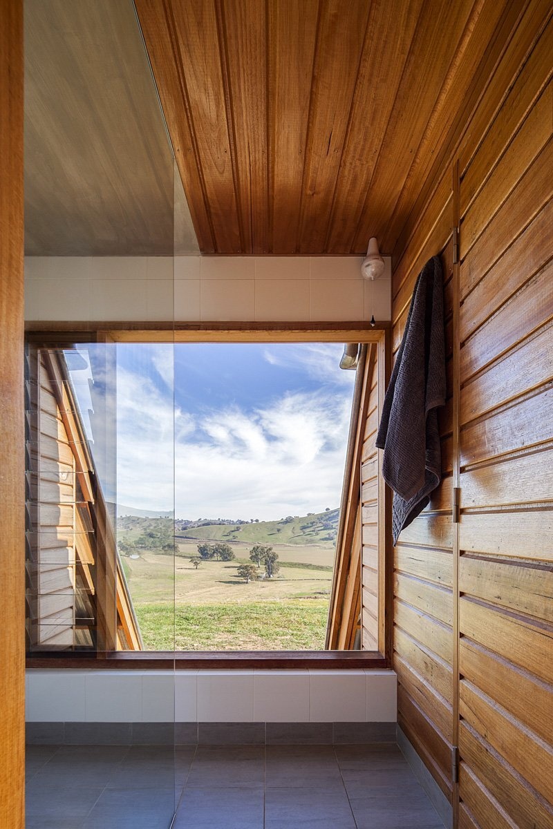 In this bathroom, a large window frames the farmland beyond, making everyday routines feel like part of the rural escape.