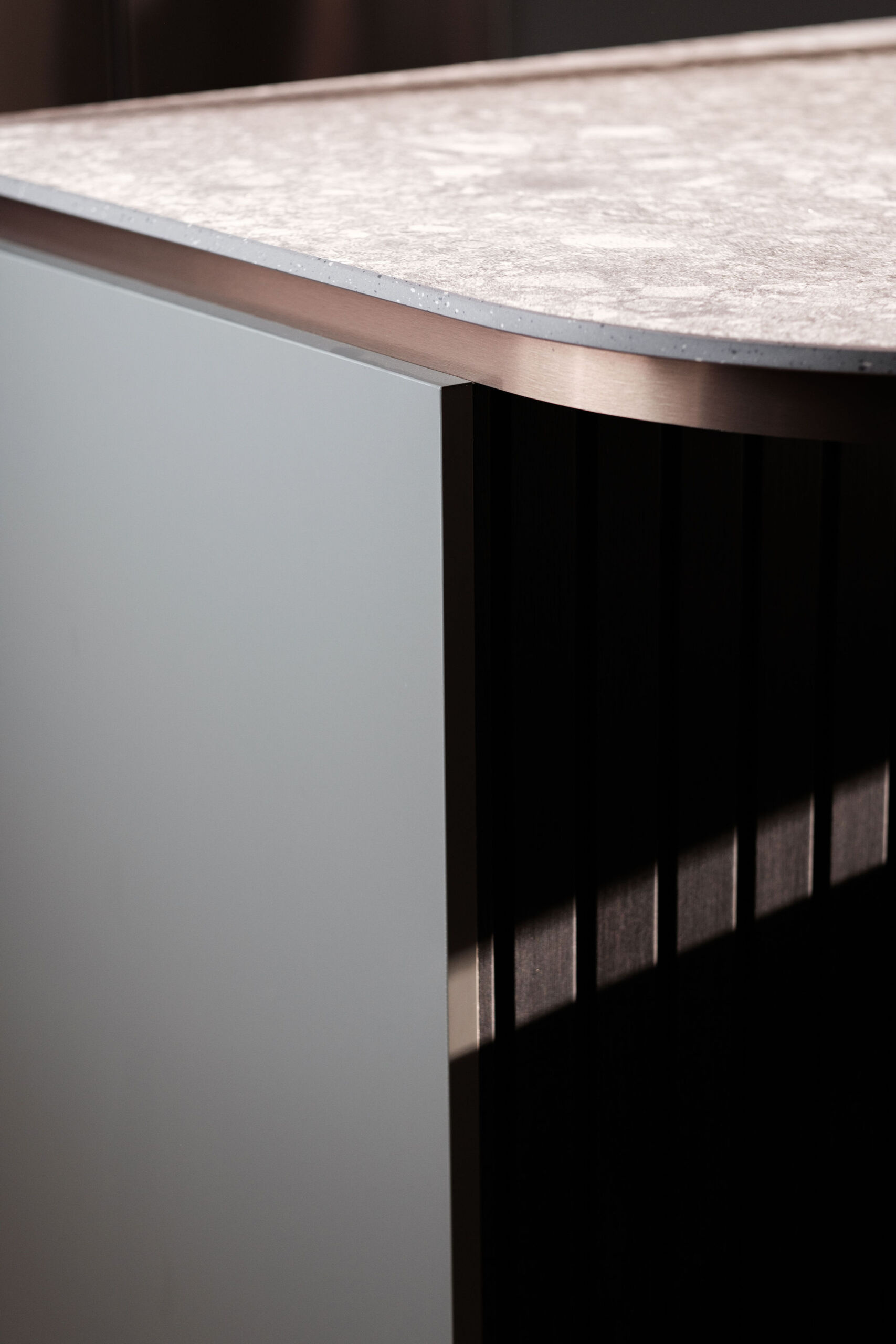 A nature inspired kitchen with stone countertops, green joinery, a tiled hood and soft eastern light flooding through a new window.