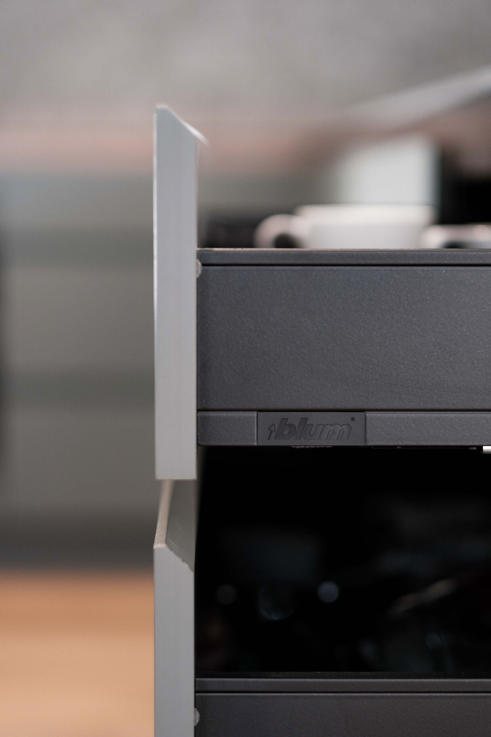 A nature inspired kitchen with stone countertops, green joinery, a tiled hood and soft eastern light flooding through a new window.