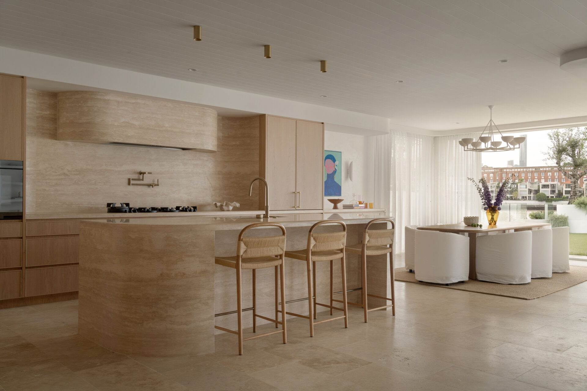 A serene dining area bridging the kitchen and outdoor spaces with warm textures and relaxed elegance.