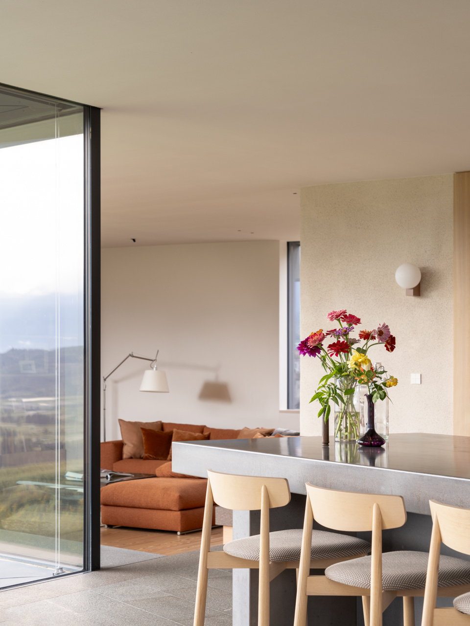 Larch wood, concrete, and stainless steel come together in a kitchen designed for shared cooking and everyday family life.