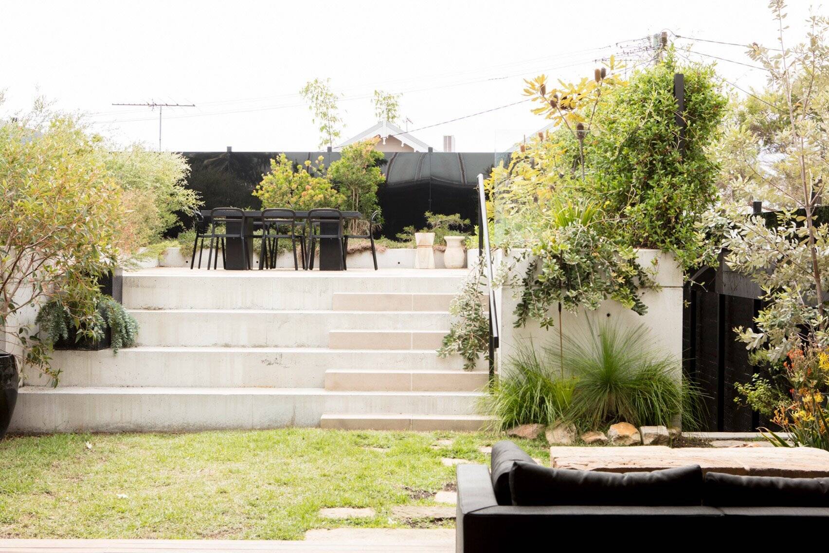 Full height sliding doors open the living and dining areas to a raised backyard dining zone filled with natural light.