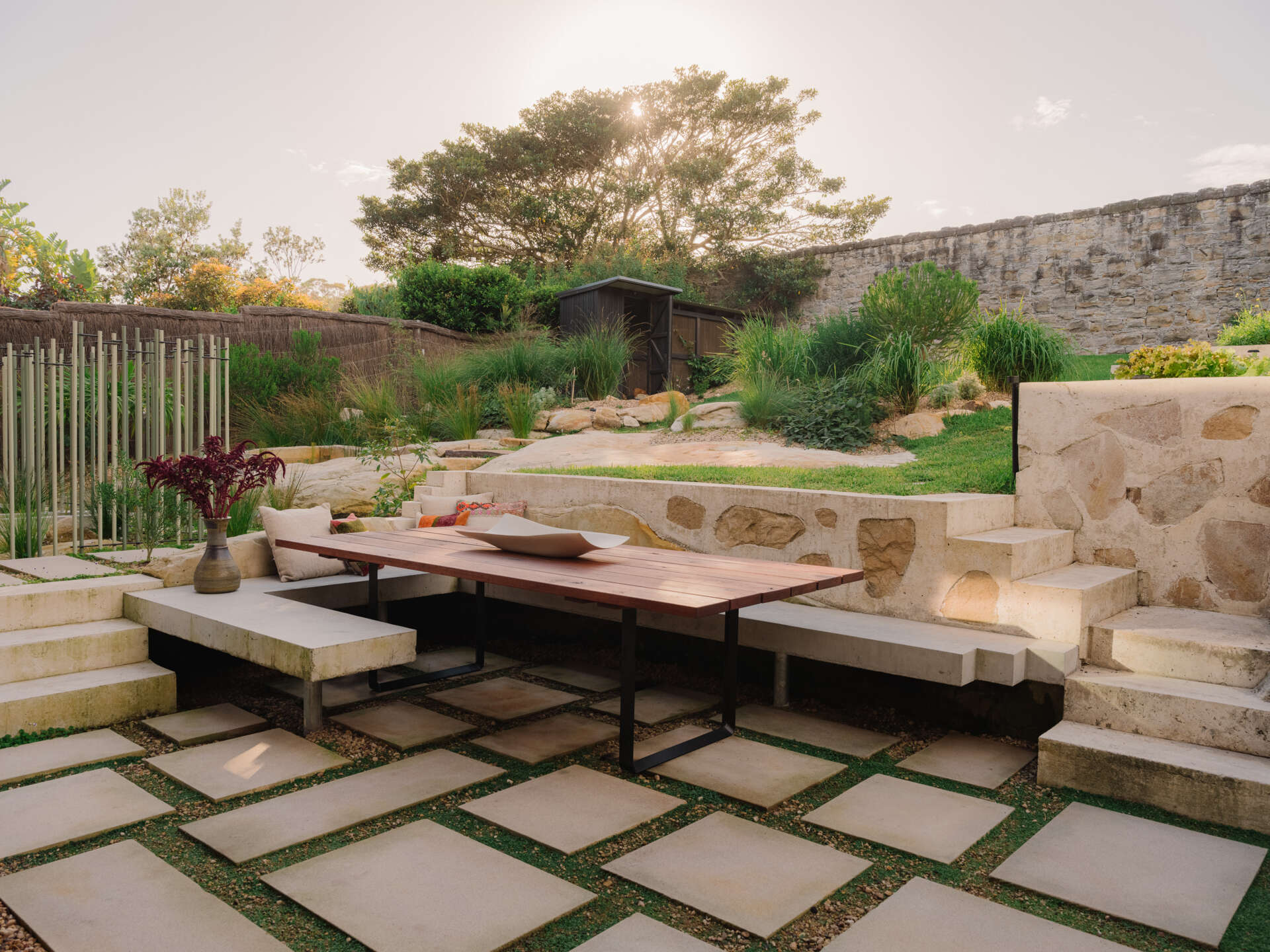 This garden supports self sufficiency with fruit trees, vegetables and herbs, while composting and mulching feed the soil, and food scraps support chickens. Rainwater and grey water systems irrigate the landscape. Outdoor dining areas sit within this productive garden, surrounded by plants selected to strengthen local ecology and support bandicoot habitat.