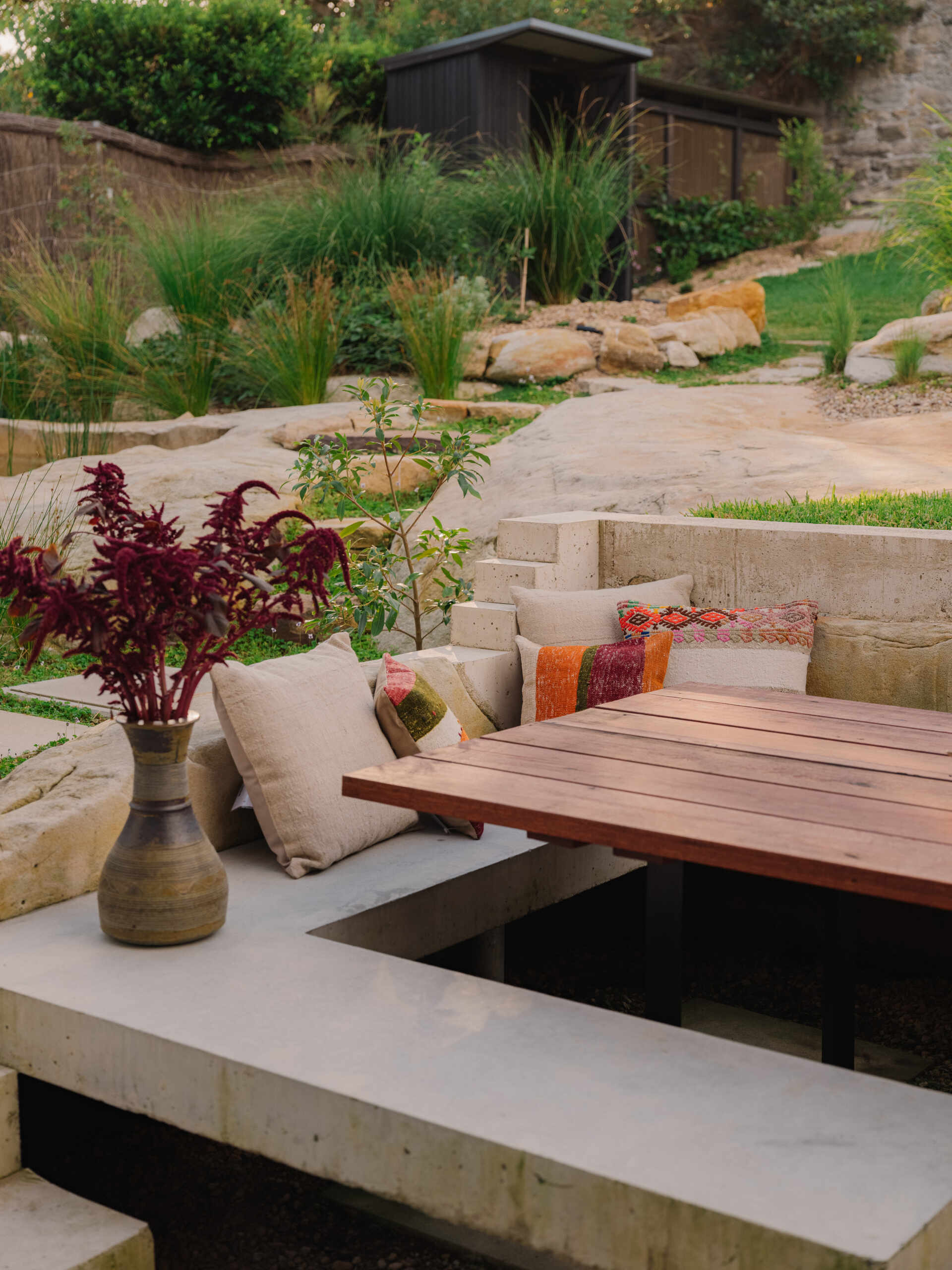 This garden supports self sufficiency with fruit trees, vegetables and herbs, while composting and mulching feed the soil, and food scraps support chickens. Rainwater and grey water systems irrigate the landscape. Outdoor dining areas sit within this productive garden, surrounded by plants selected to strengthen local ecology and support bandicoot habitat.