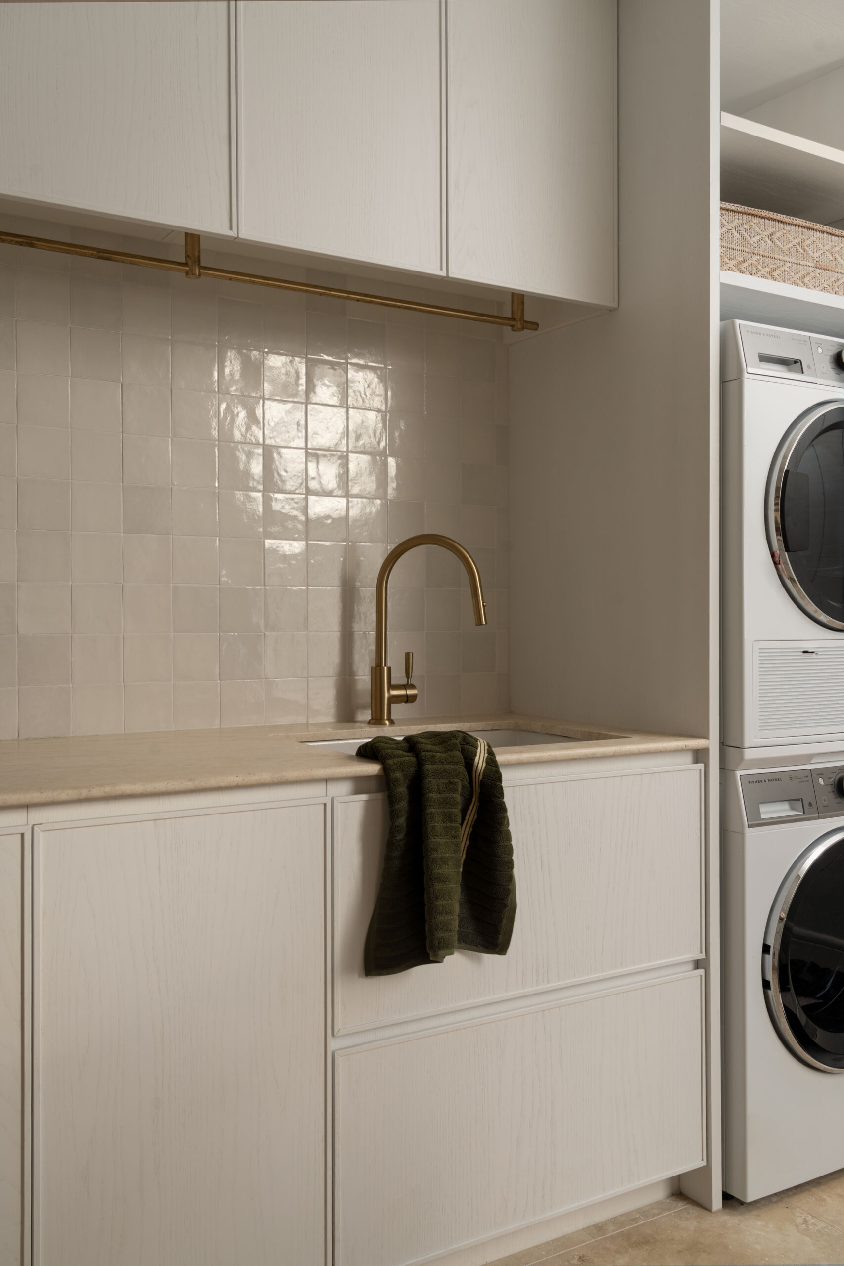 A warm, minimal laundry that continues the Mediterranean textures seen throughout the home.