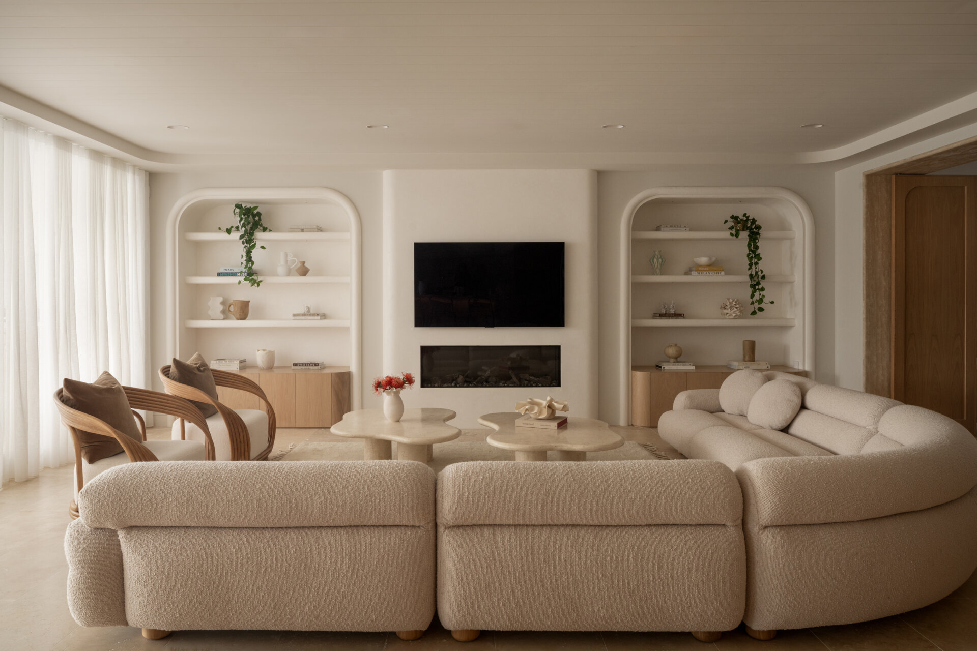 A warm living space with bullnose archways and a sculptural, cave-like wine cellar tucked into the wall.