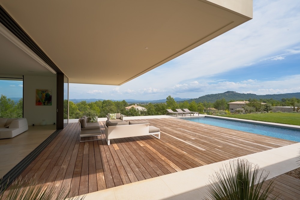 Retractable glass walls in the living room open directly onto the deck and swimming pool, blending interior and exterior spaces seamlessly.