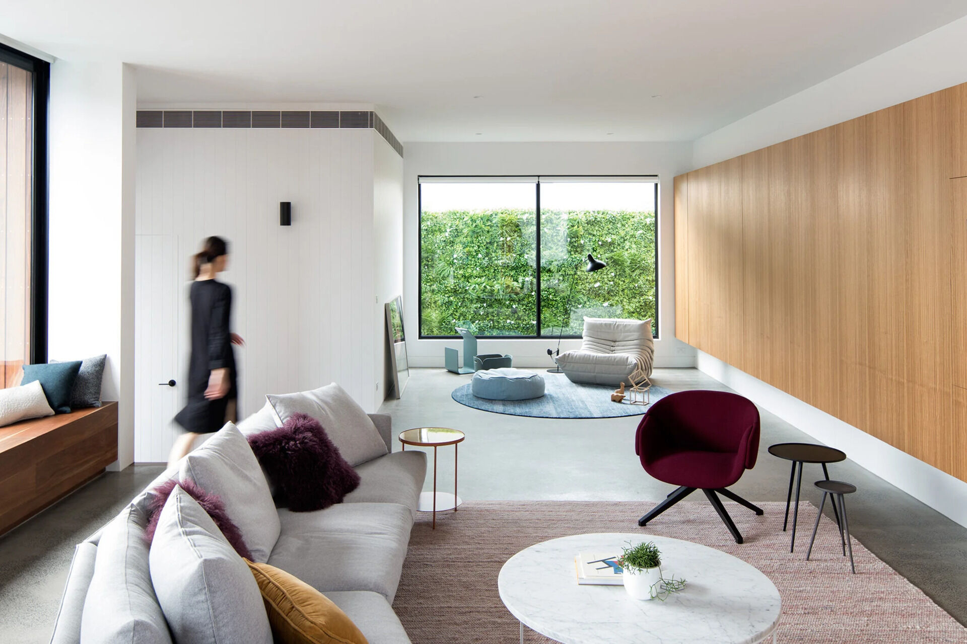 A sun-filled living room with a peaceful reading nook offers light and calm in a modern Melbourne home.