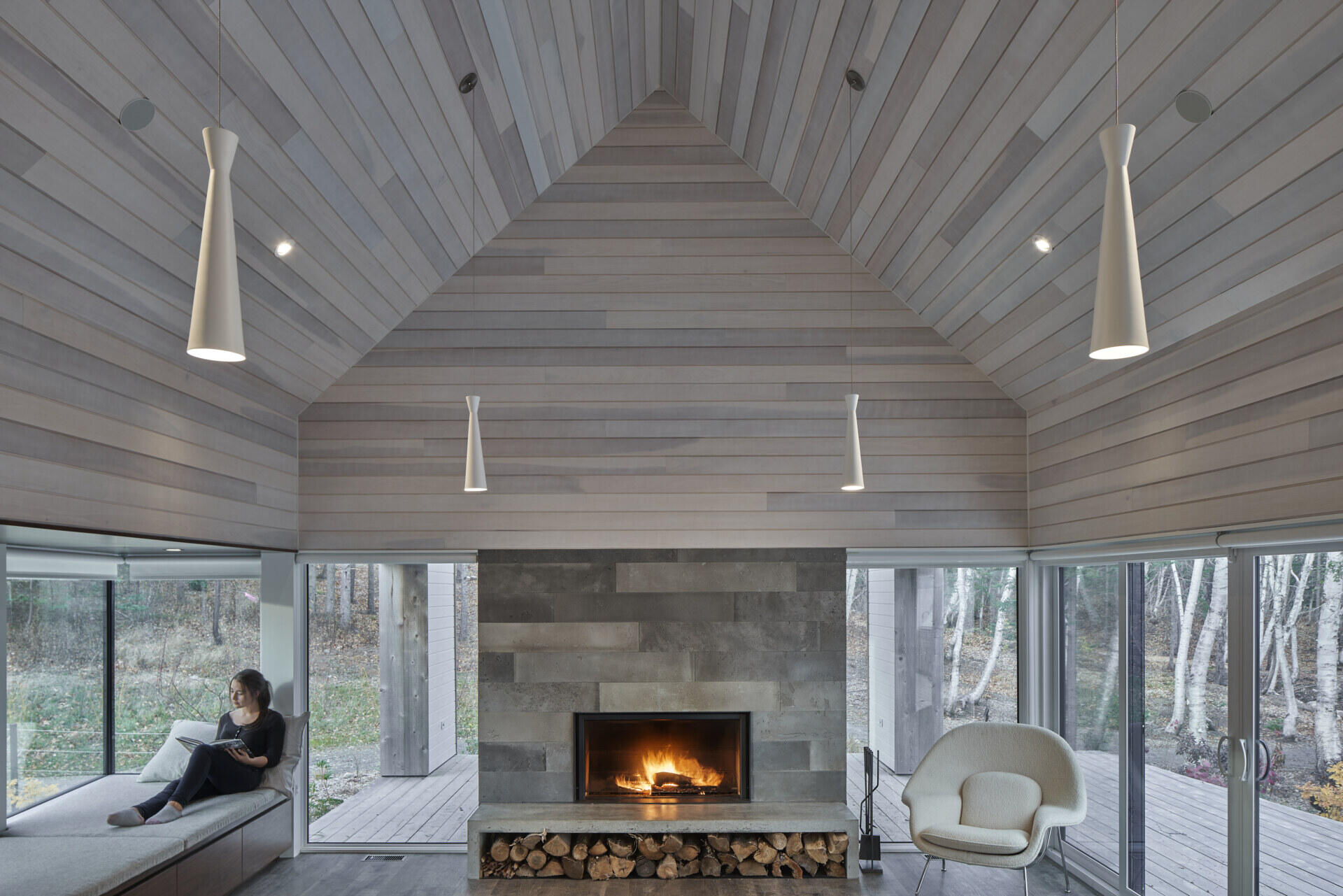 Sala de estar moderna con chimenea y asiento junto a la ventana.
