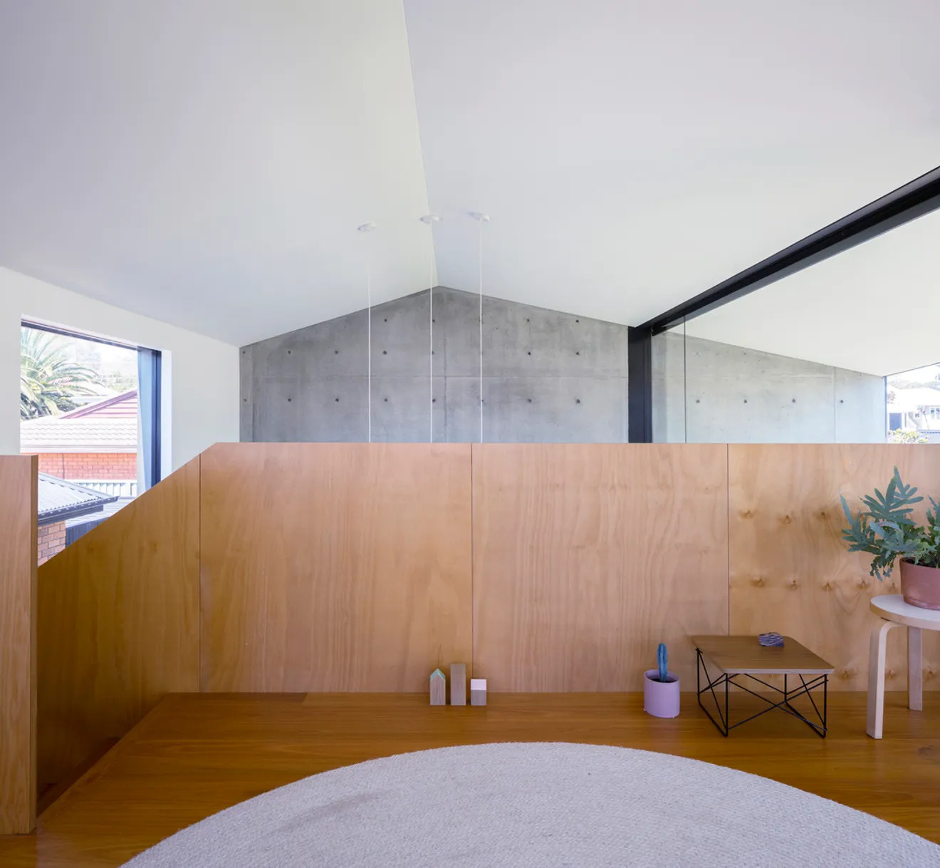 A lofted second living space overlooks the double-height living room below.