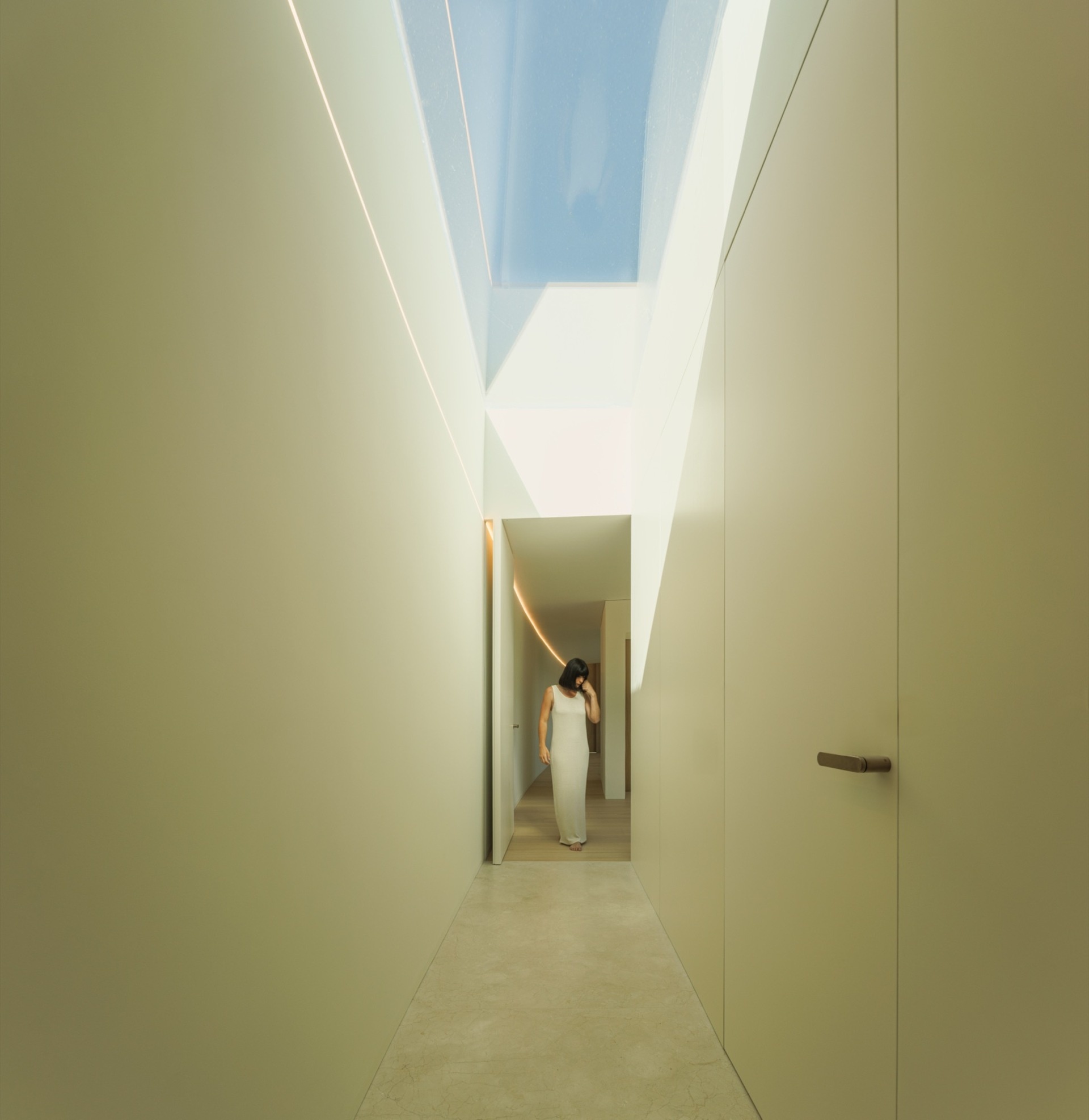 In this minimalist home, hallways are shaped by curved volumes, turning them into active connectors rather than leftover space.