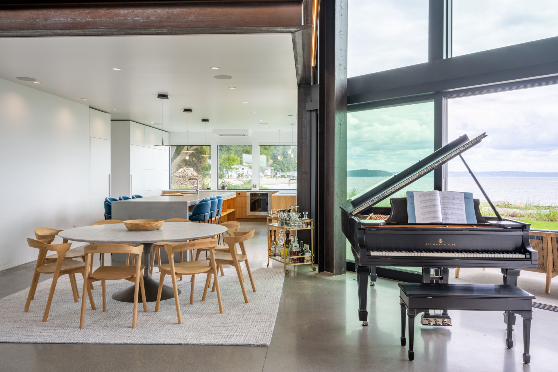 The dining area, with its round table, is integrated into the open great room between the living room and the kitchen.